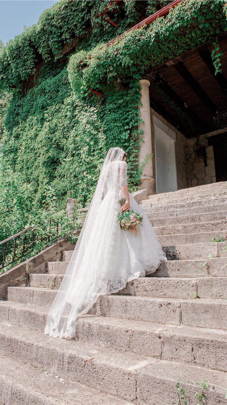 A bride sitting on the steps of her wedding venue - Wedding