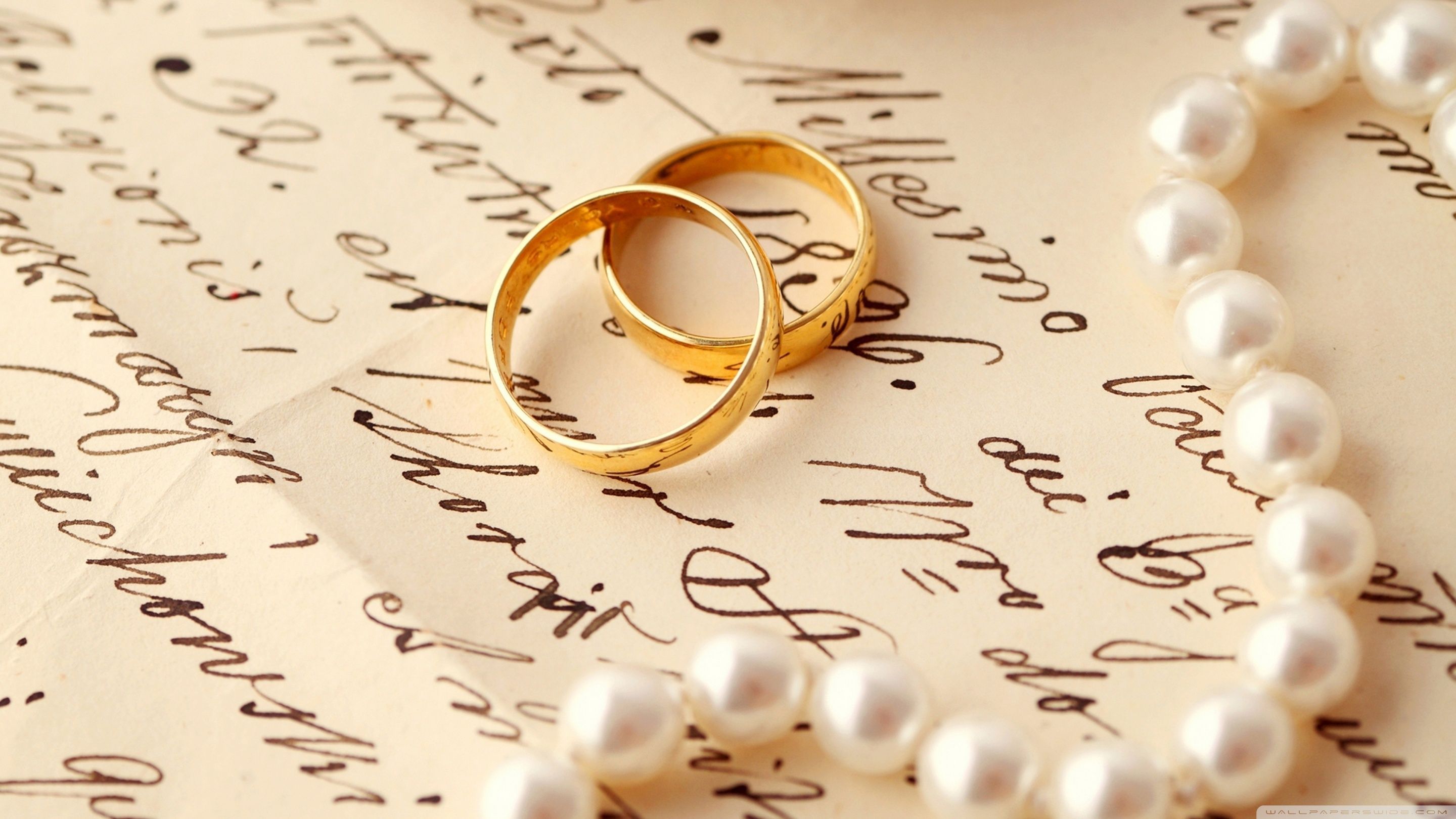 Two gold wedding rings on a piece of paper - Wedding