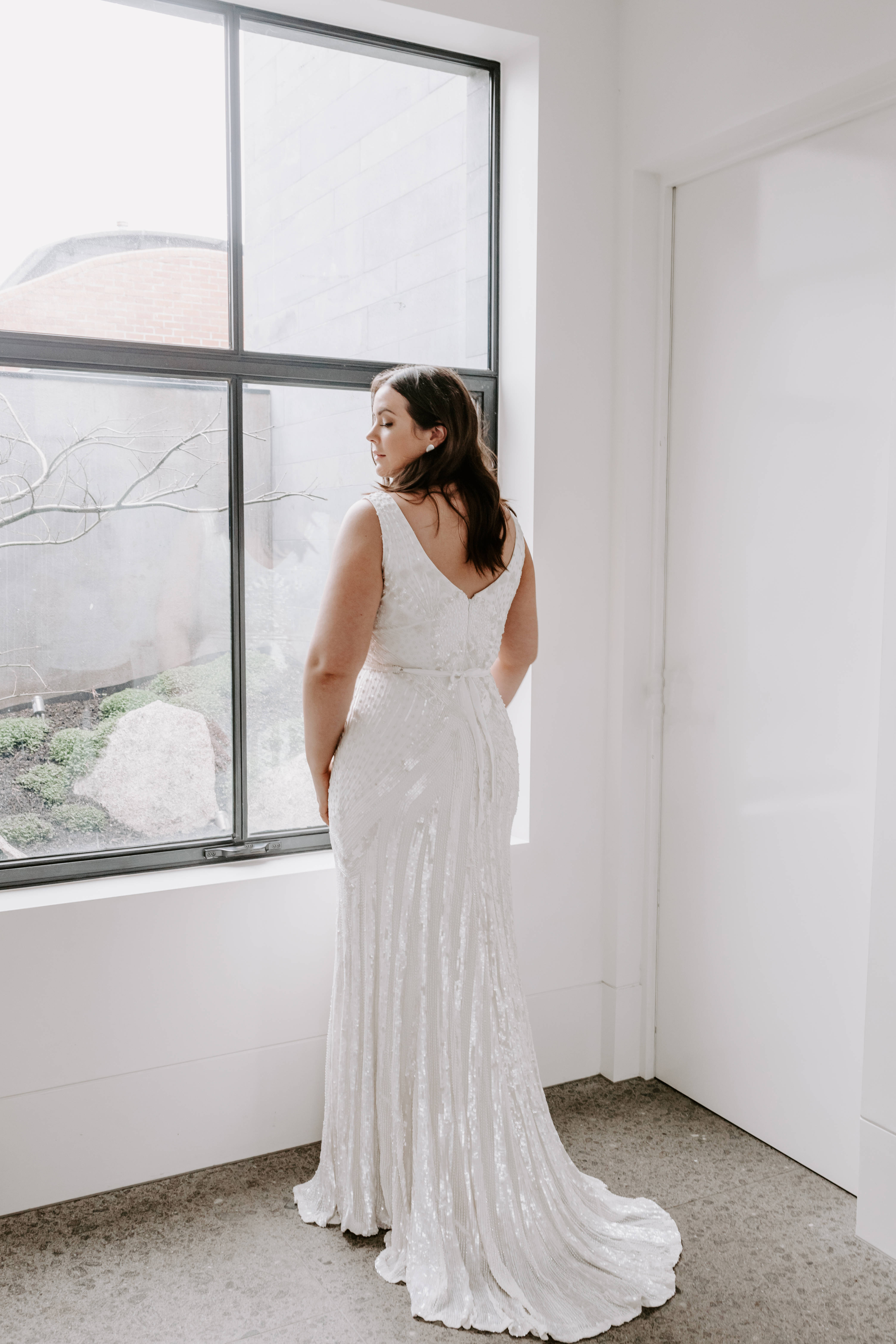 Plus size bride looking out the window in a lace wedding dress - Wedding
