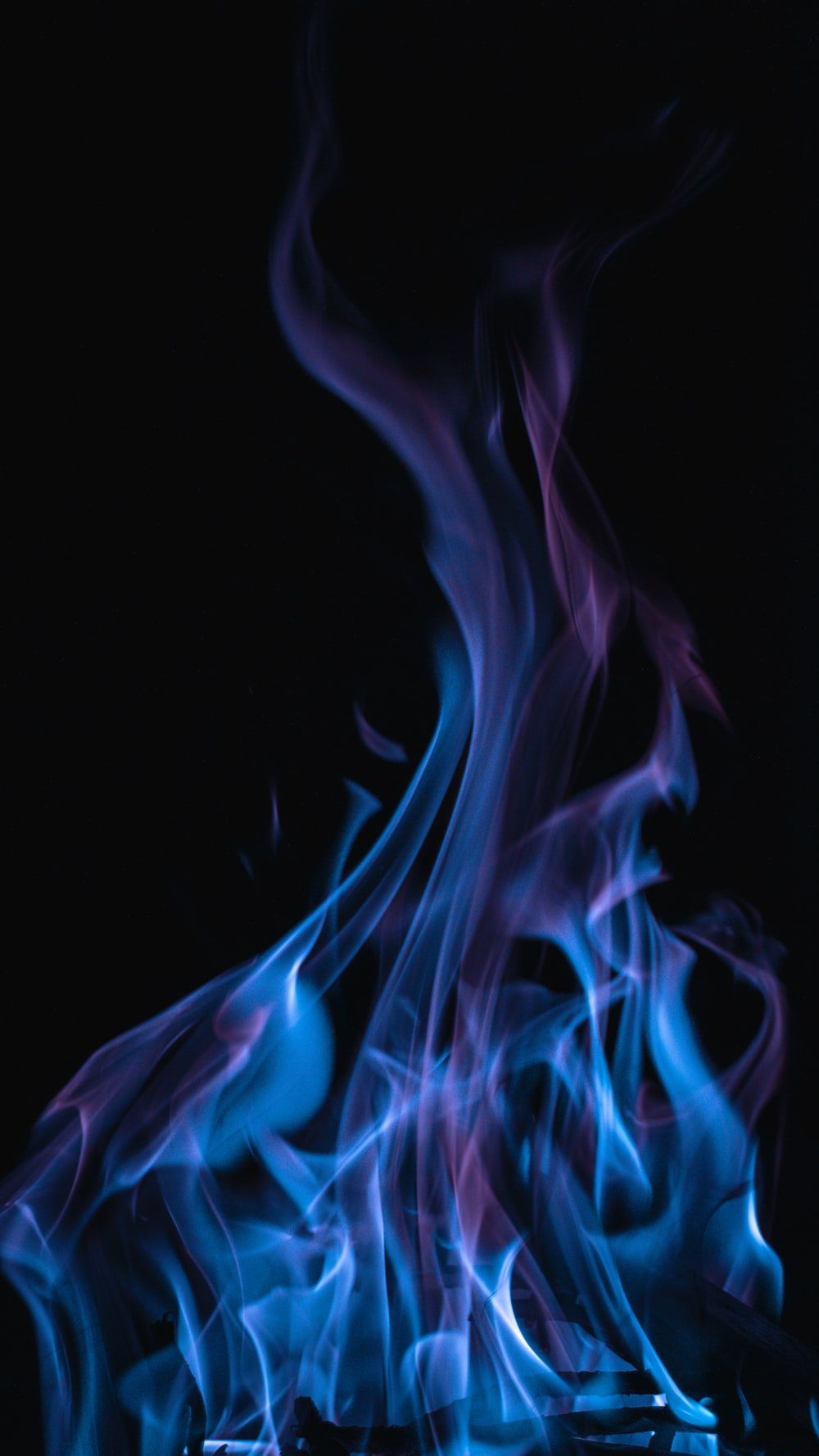 A blue and purple fire on a black background - Flames, fire