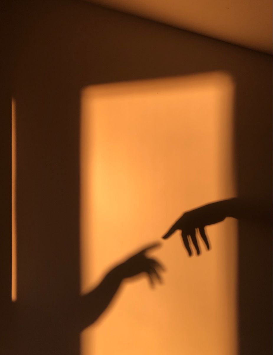 A shadow of two hands reaching out from the wall - Shadow