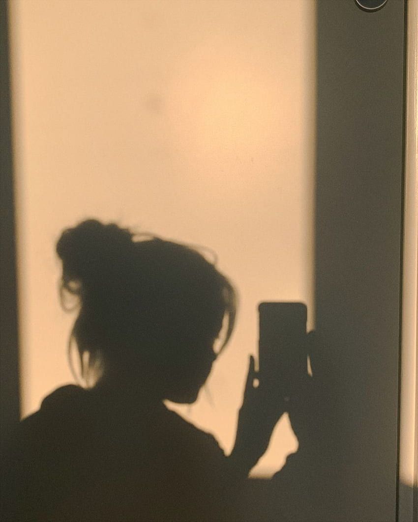 A shadow of a woman holding a phone. - Shadow