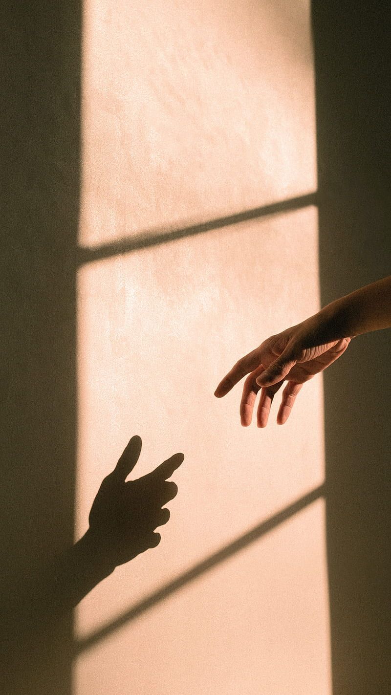 Two hands reaching out for each other through a window - Shadow