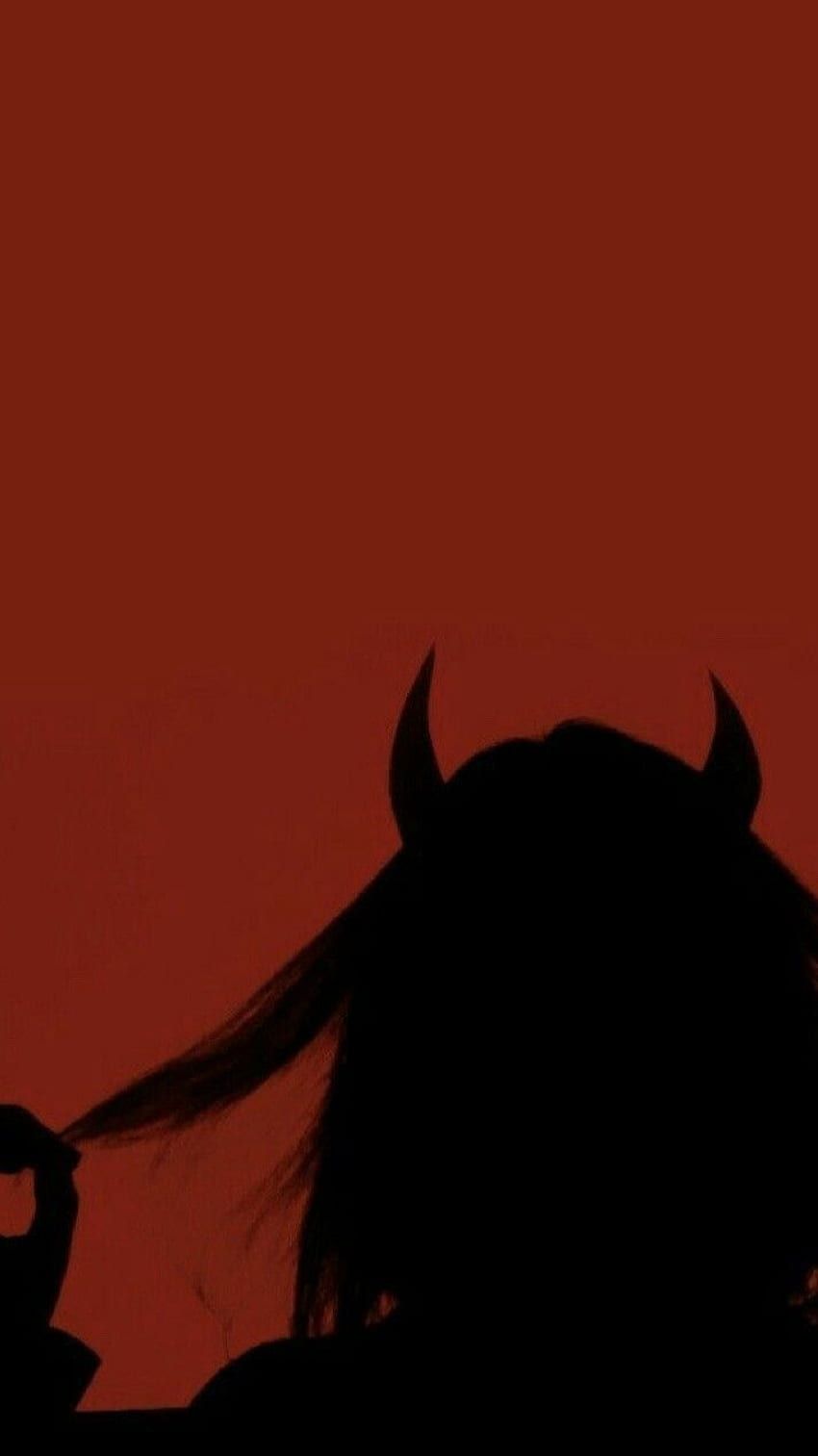 A silhouette of a woman with horns against a red sky - Shadow