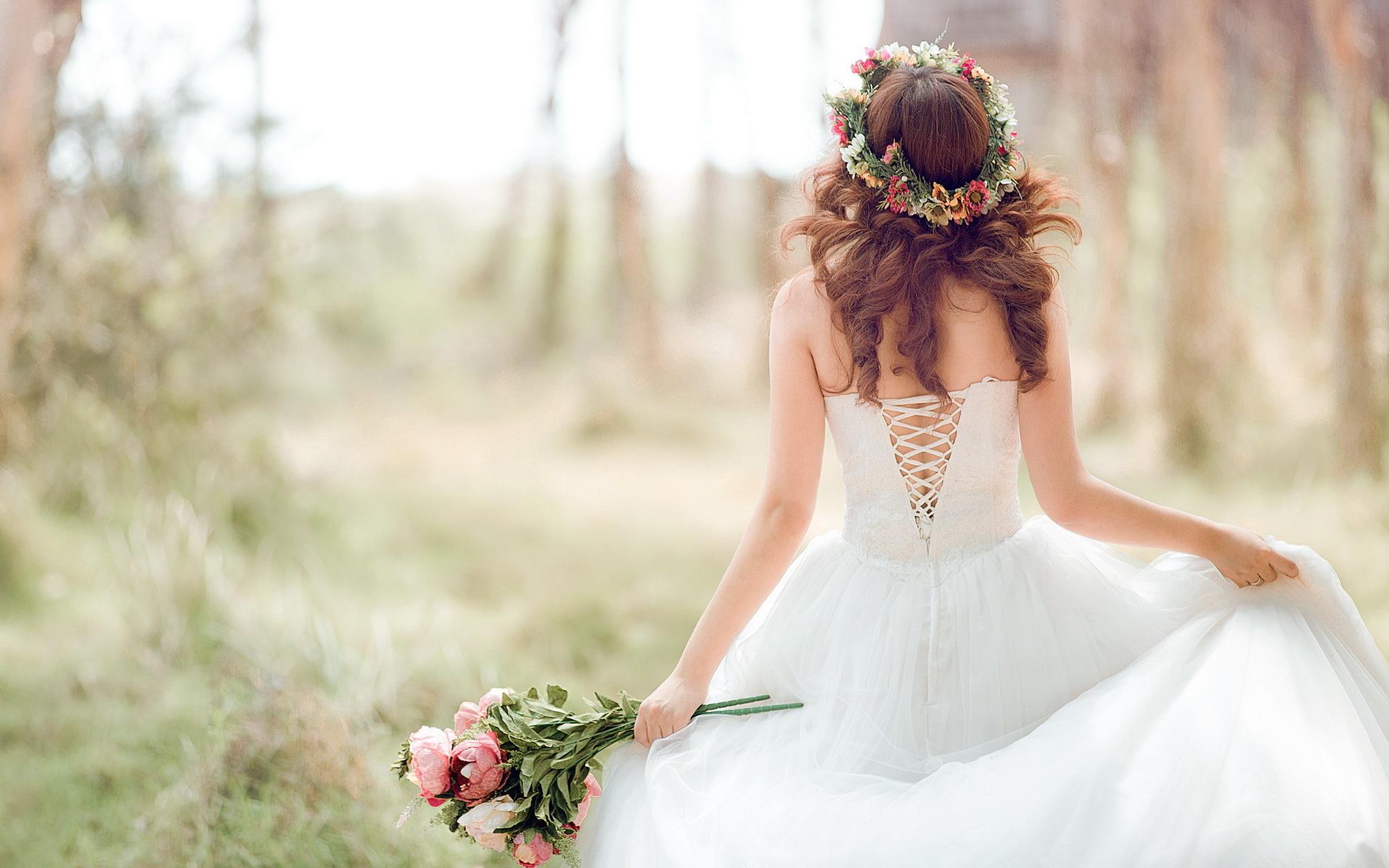 Bride in a white dress holding a bouquet of flowers - Wedding