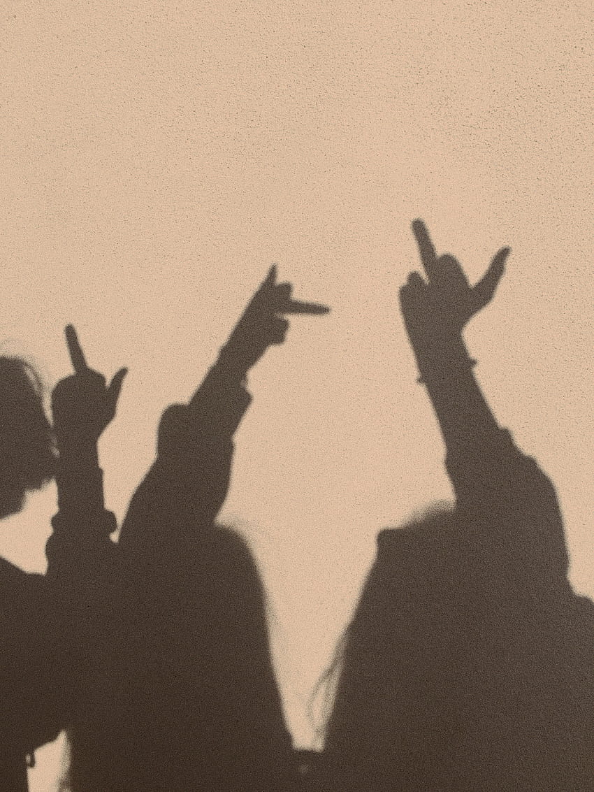 The shadows of two people against a wall, making hand gestures. - Shadow