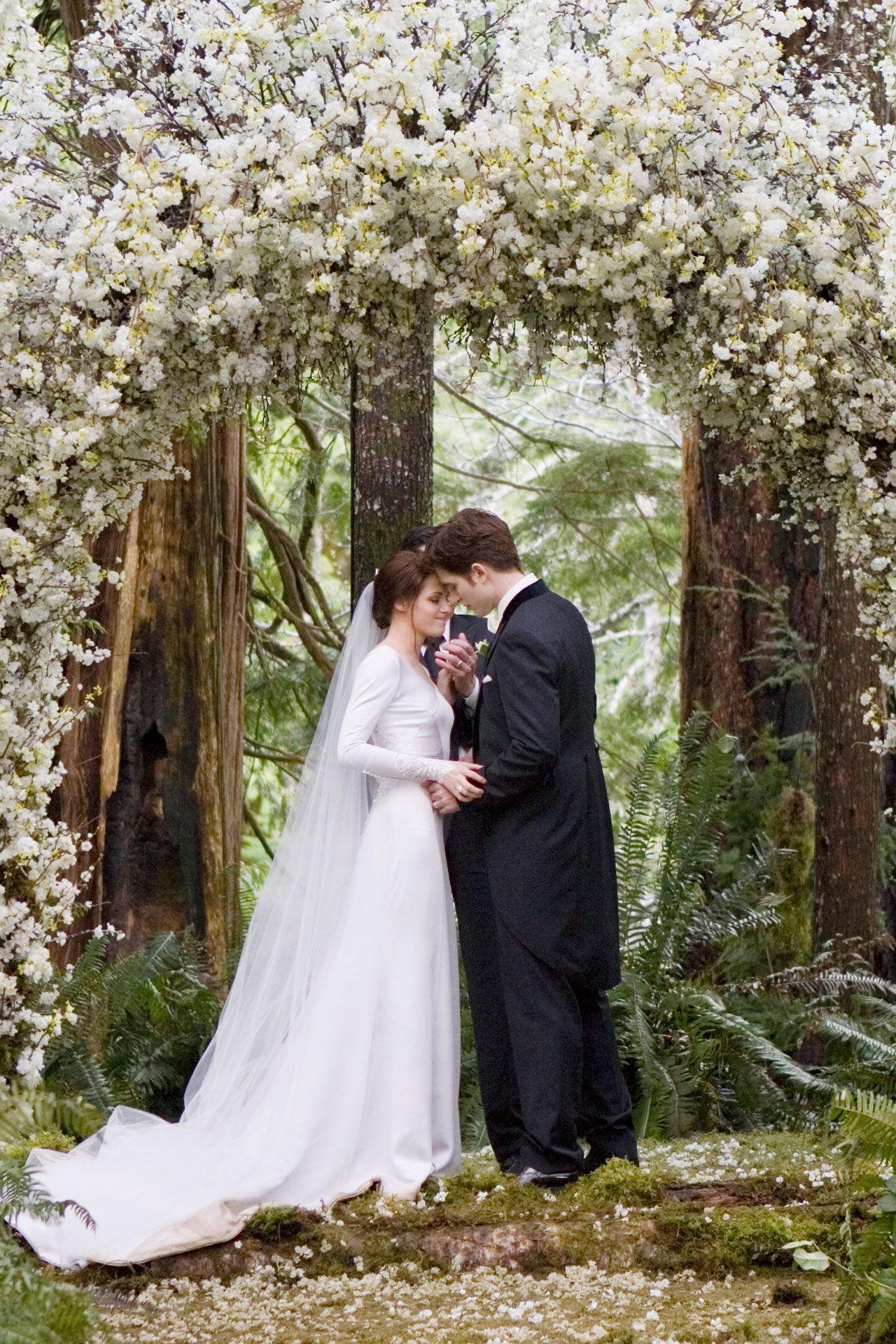 A bride and groom are standing under an archway - Wedding