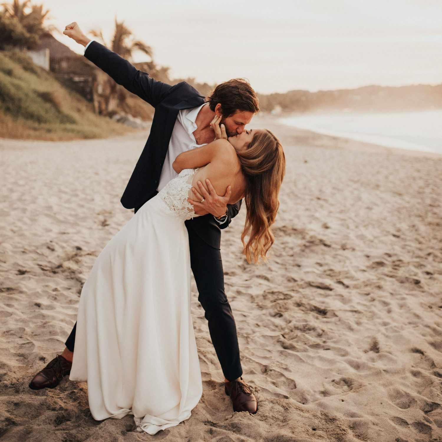 Groom dips bride on the beach - Wedding