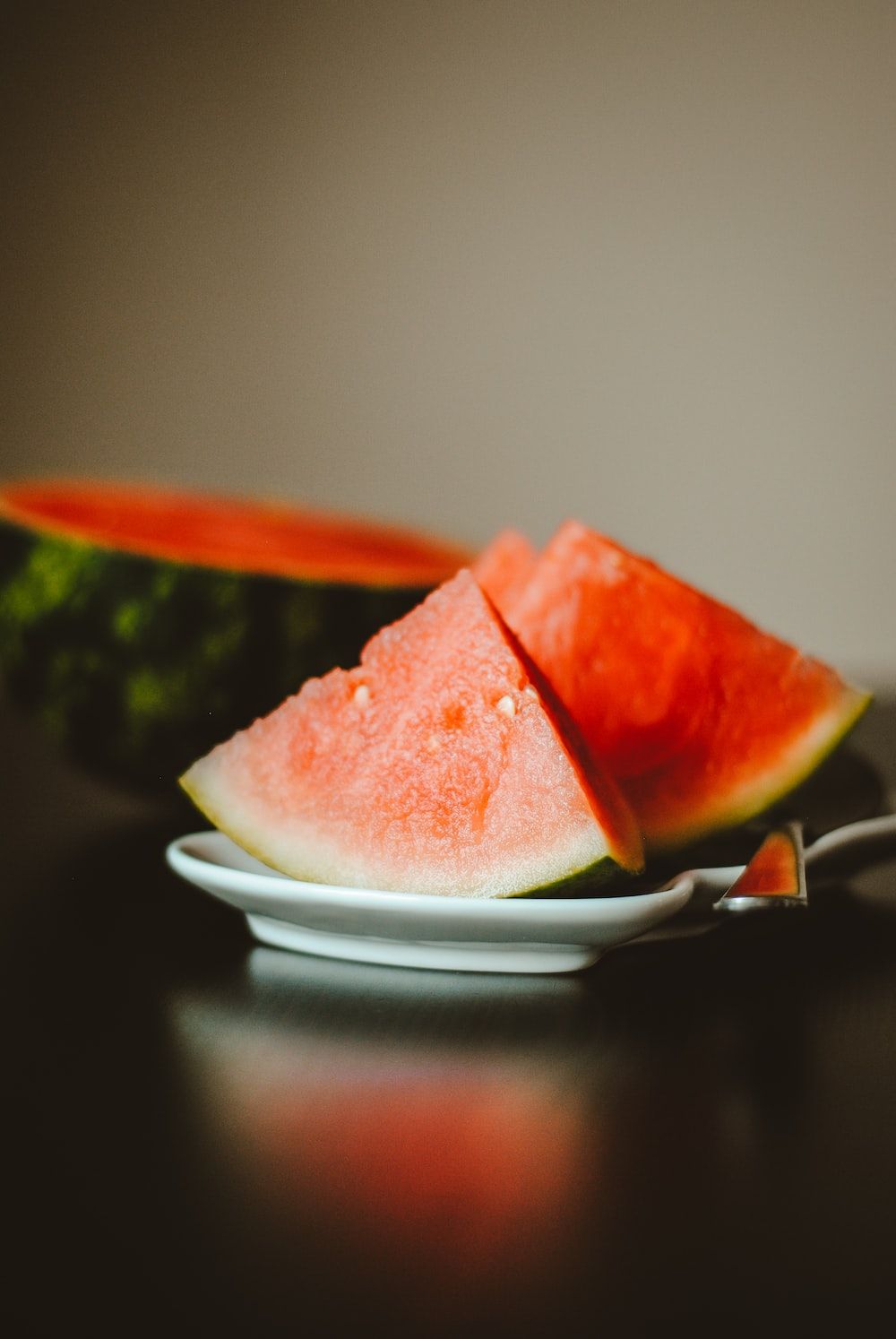 Two slices of watermelon on a white plate. - Watermelon