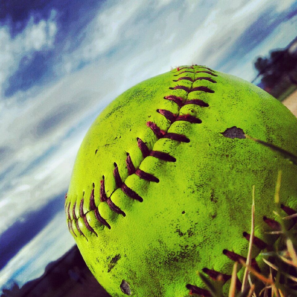 A baseball is sitting on top of some grass - Softball