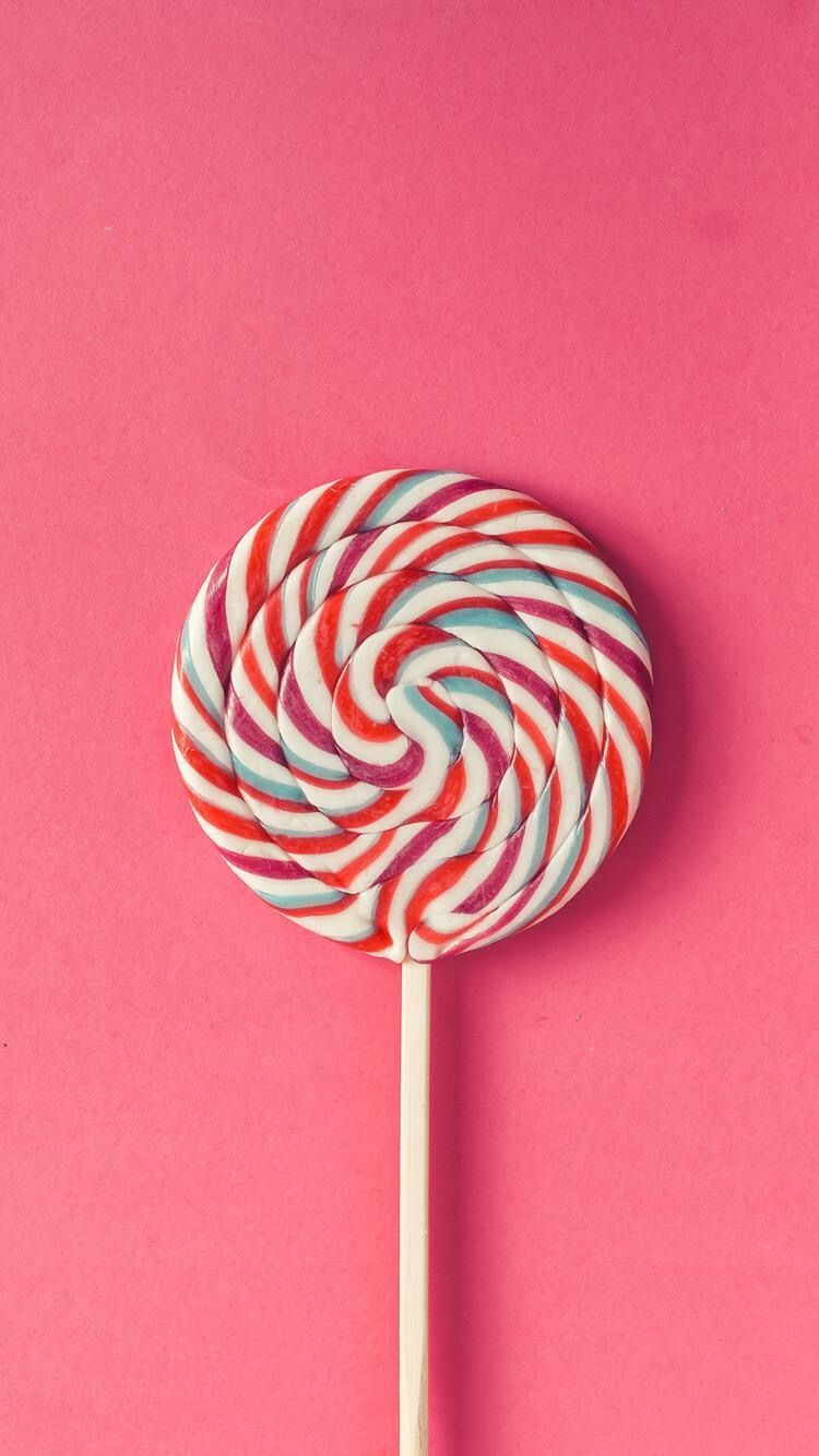 A colorful lollipop on a pink background - Candy