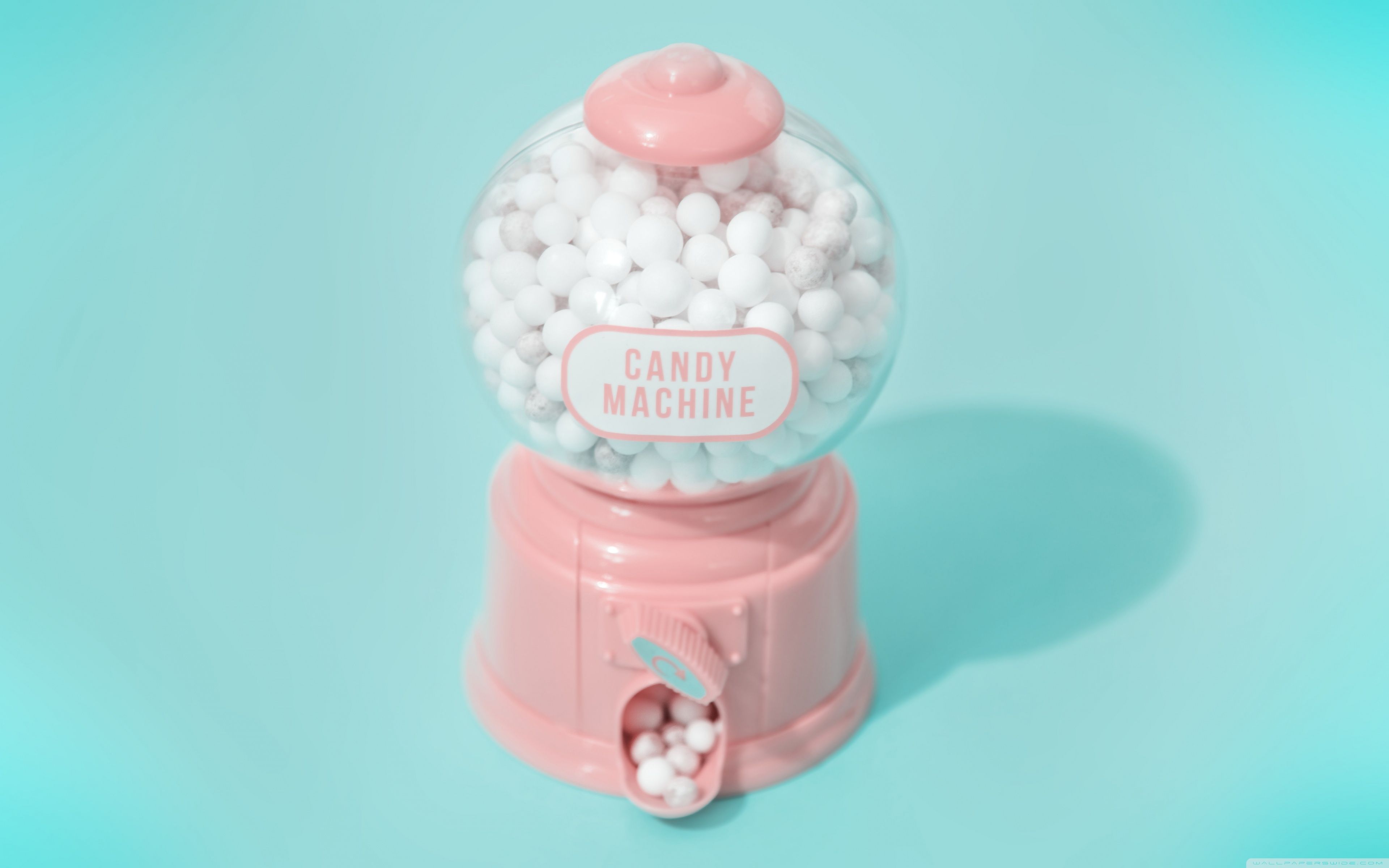 A pink candy dispenser with white candy balls - Candy