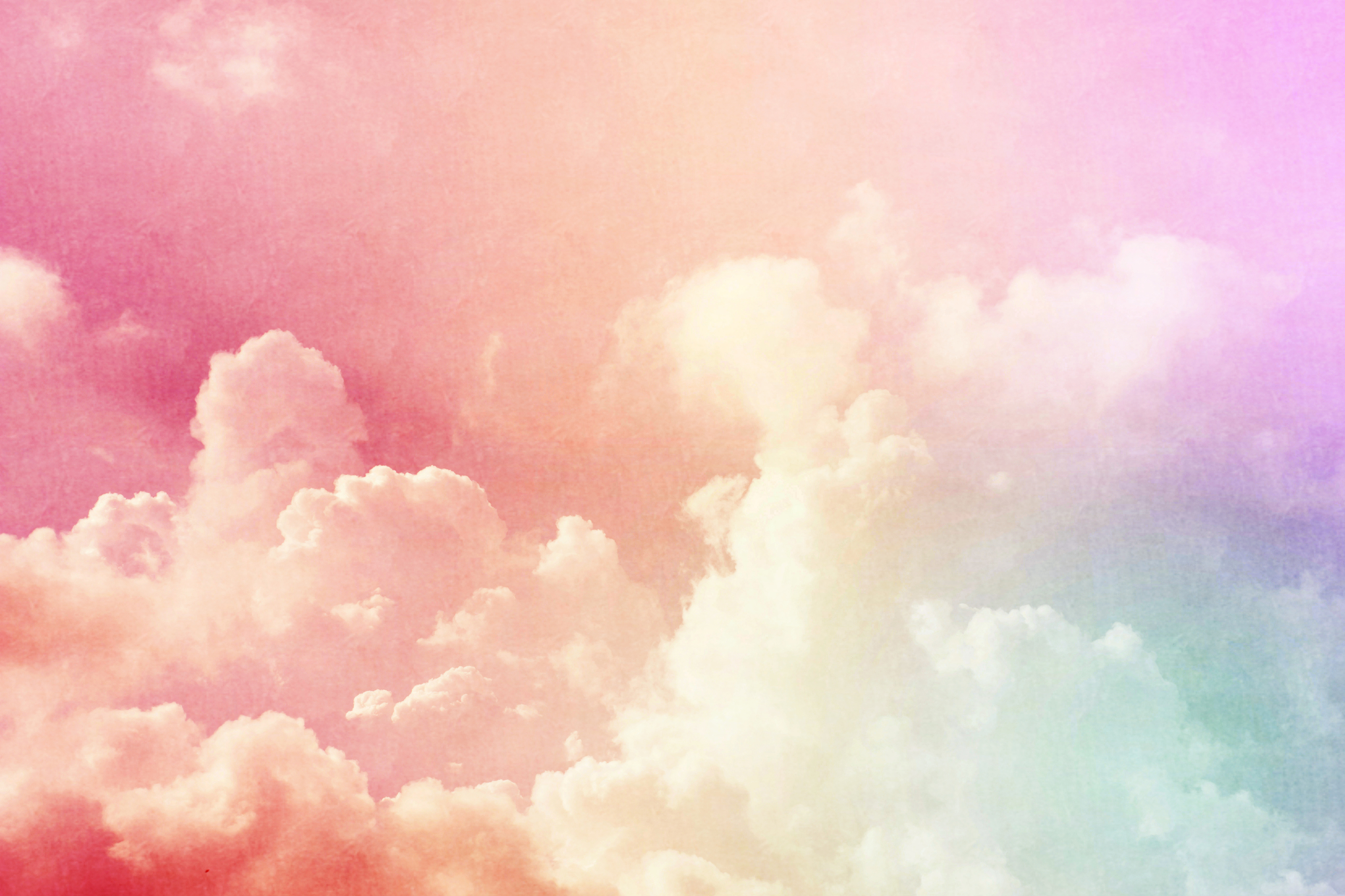 A colorful sky with clouds and an airplane - Pastel rainbow