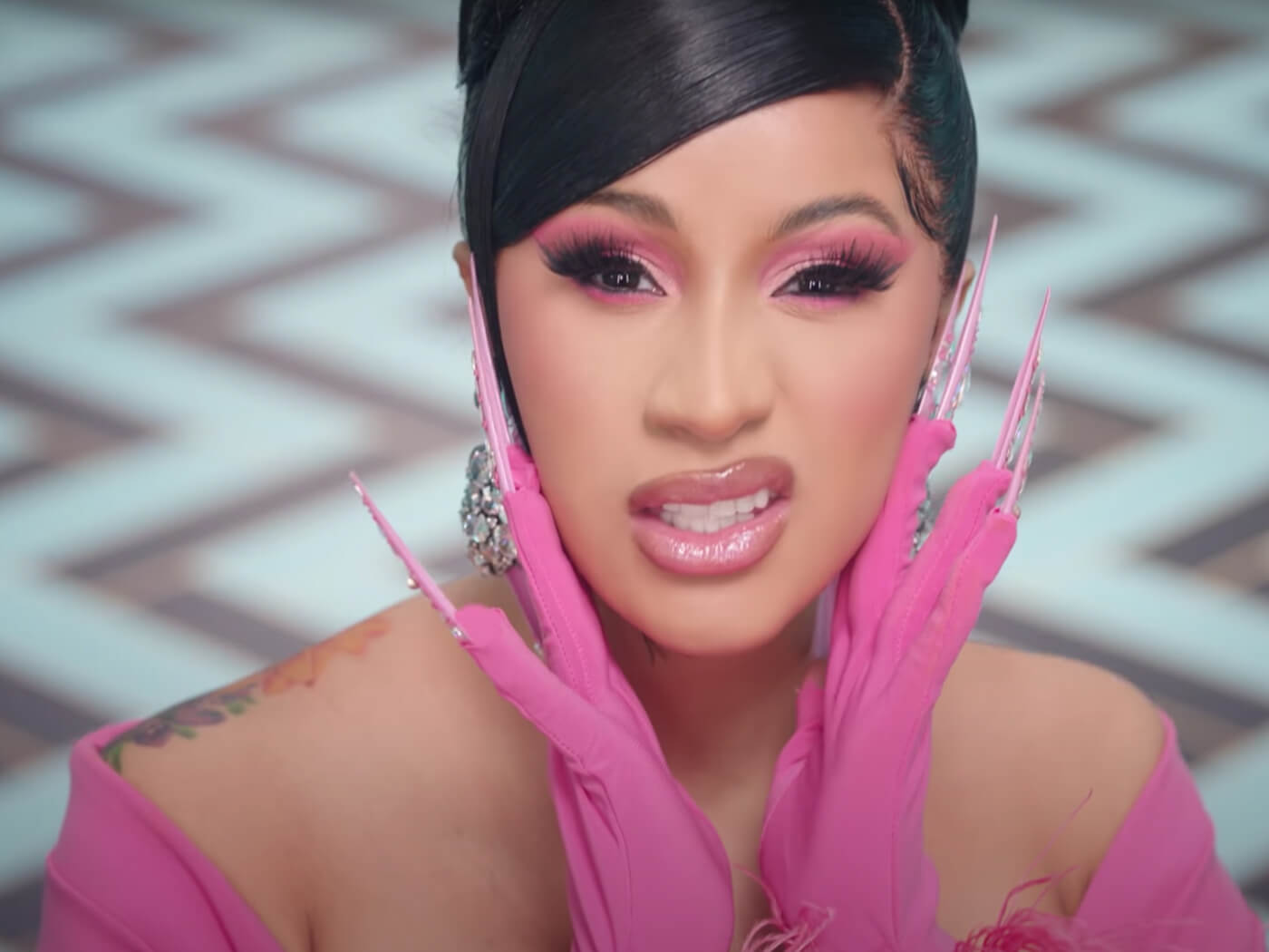 A woman in pink gloves and nail polish - Cardi B