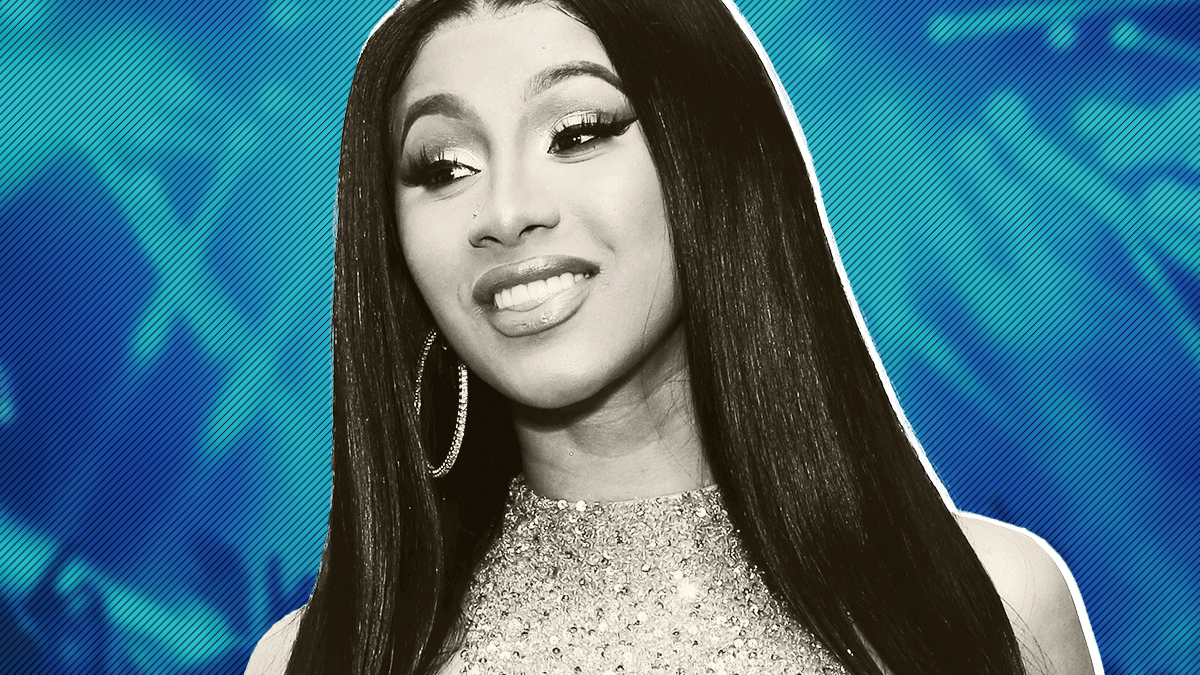 Cardi B smiling on a blue background - Cardi B