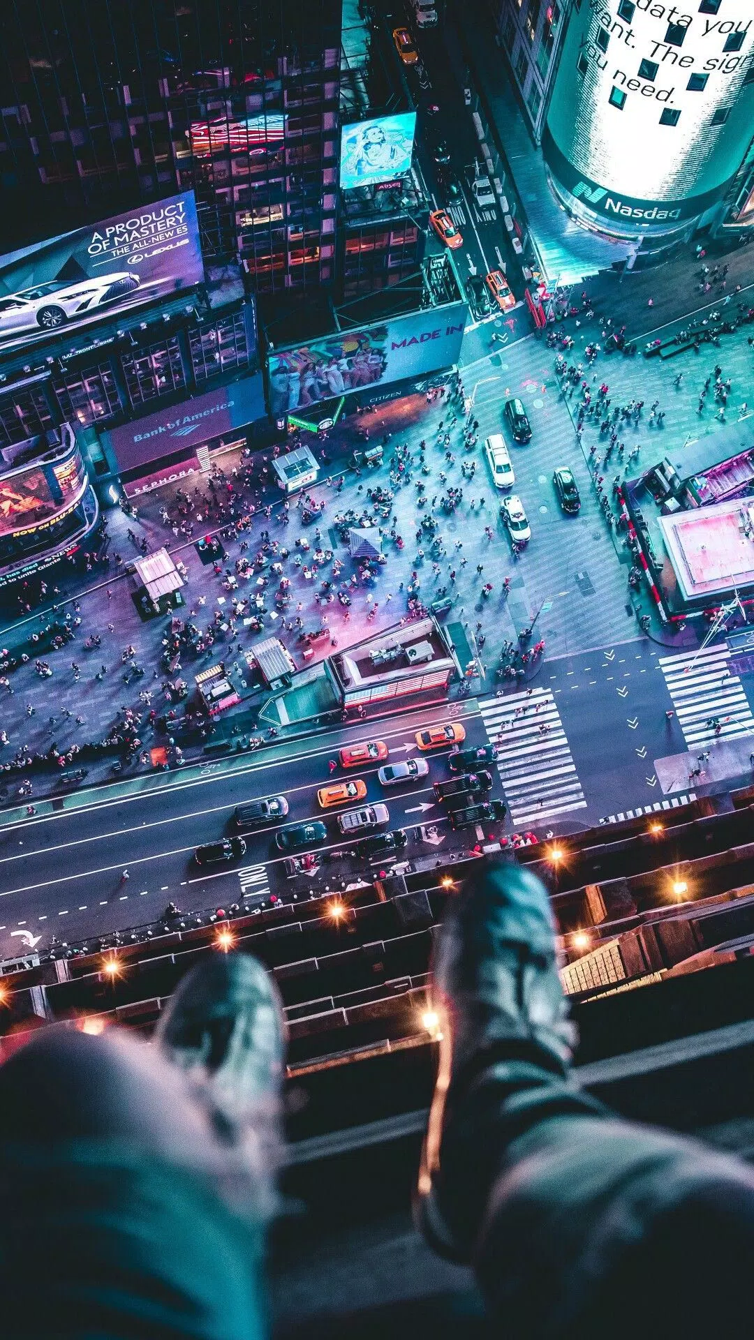 A person sitting on a ledge looking down at a busy city street - Cyberpunk, New York