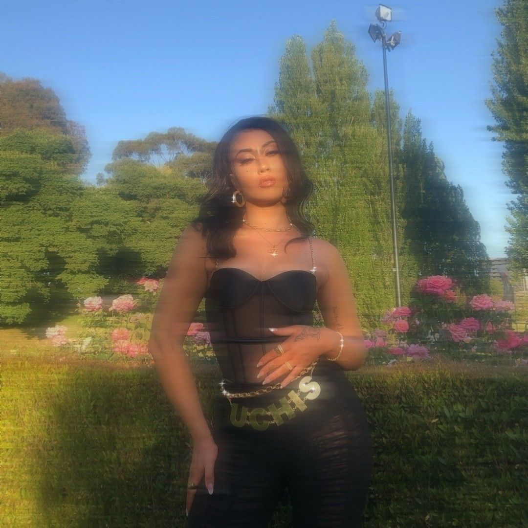 A woman in black top and pants posing for the camera - Kali Uchis