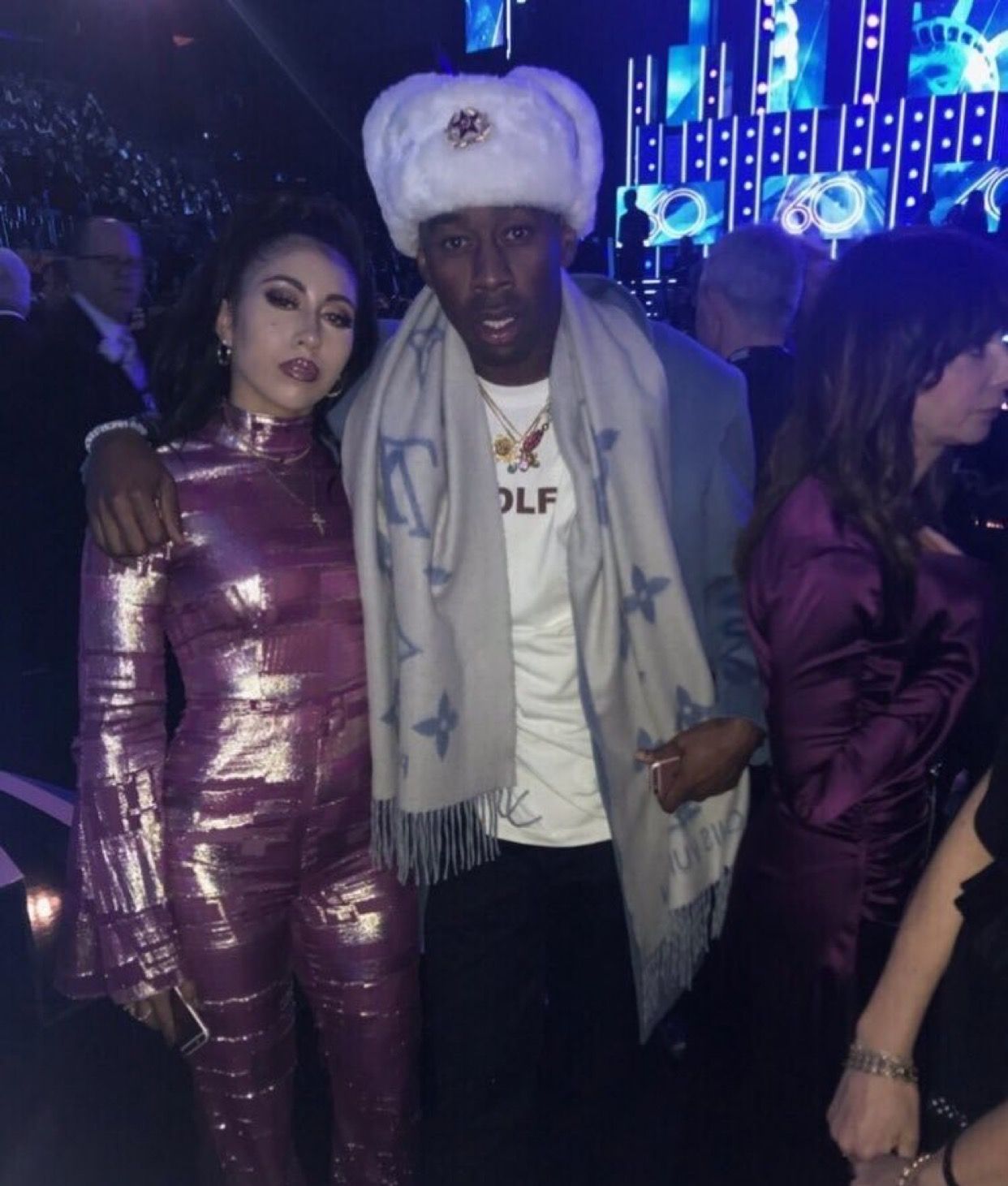 A photo of a man and a woman standing next to each other at a party. - Kali Uchis