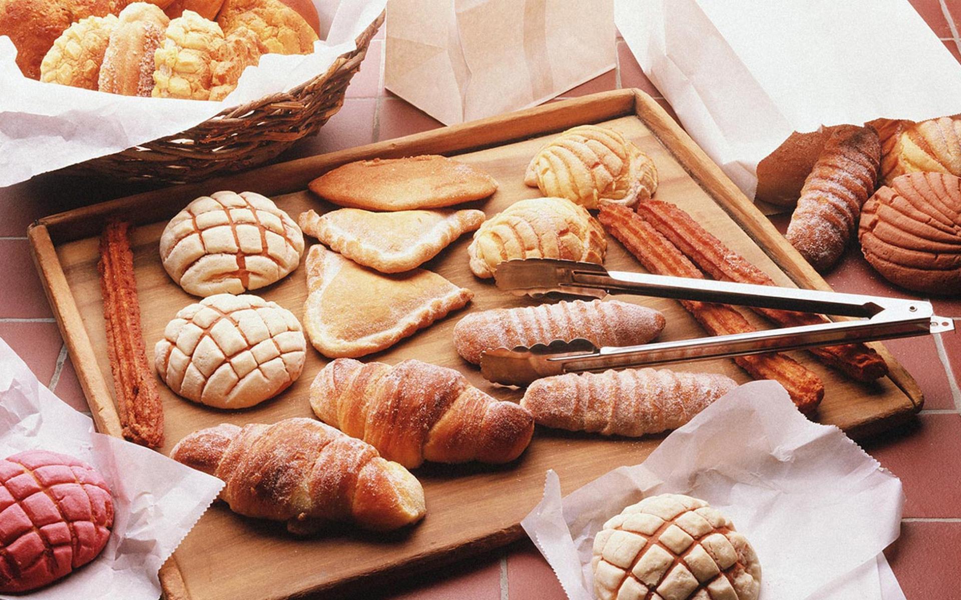 A tray of pastries and breads on display - Bakery