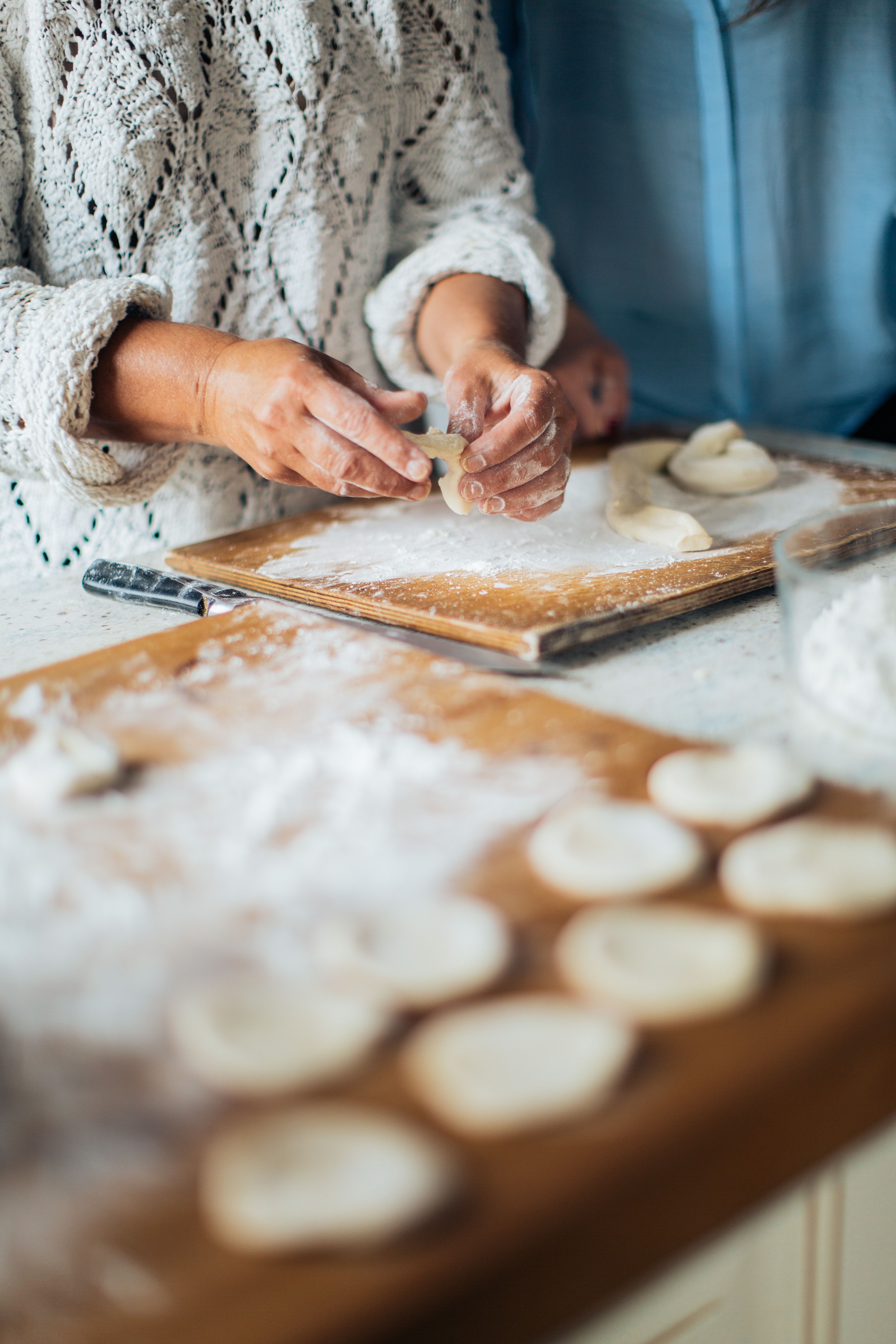 Close up of a woman's hands making dough on a counter - Bakery