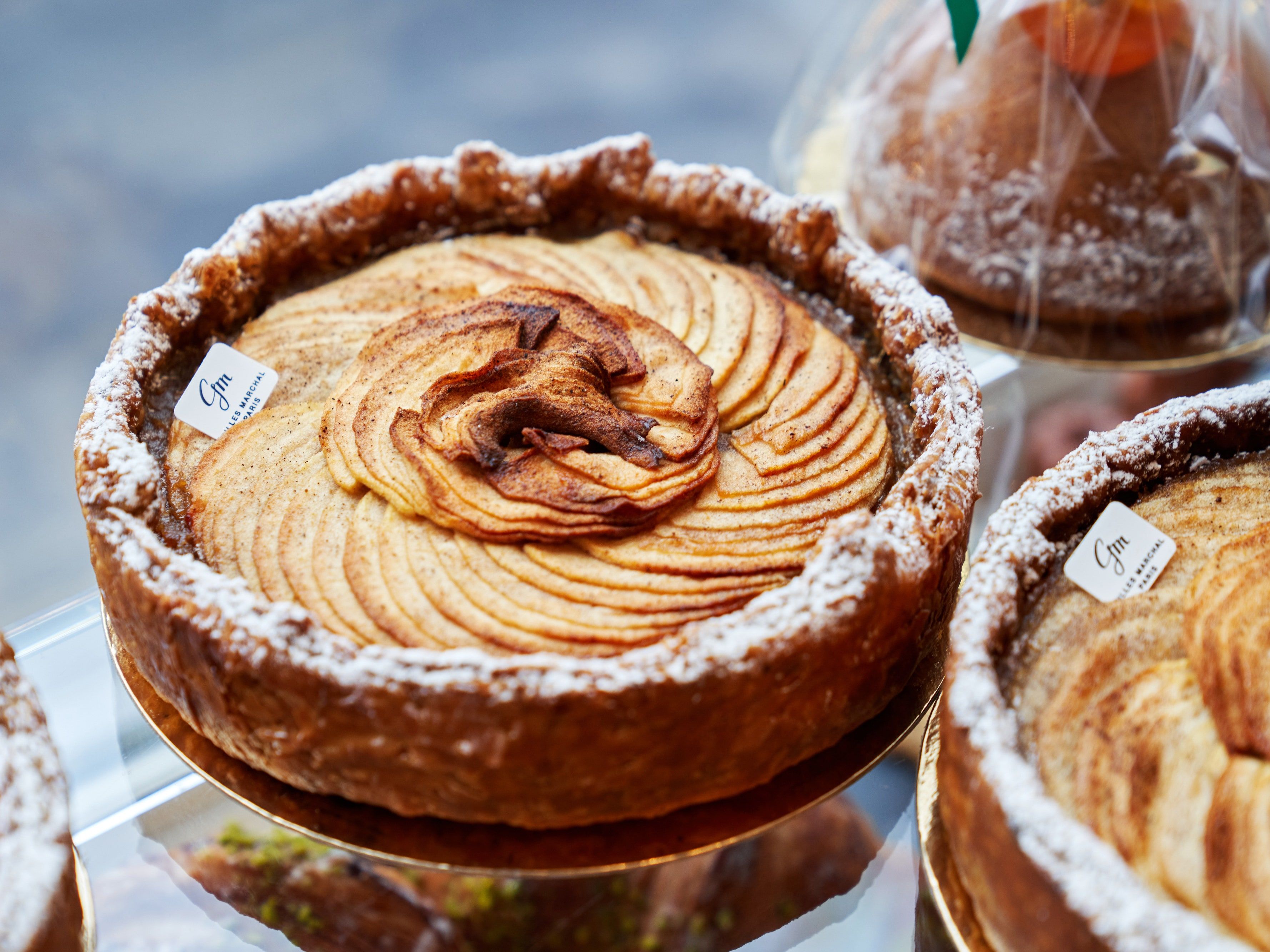 A delicious looking apple tart on a glass shelf - Bakery