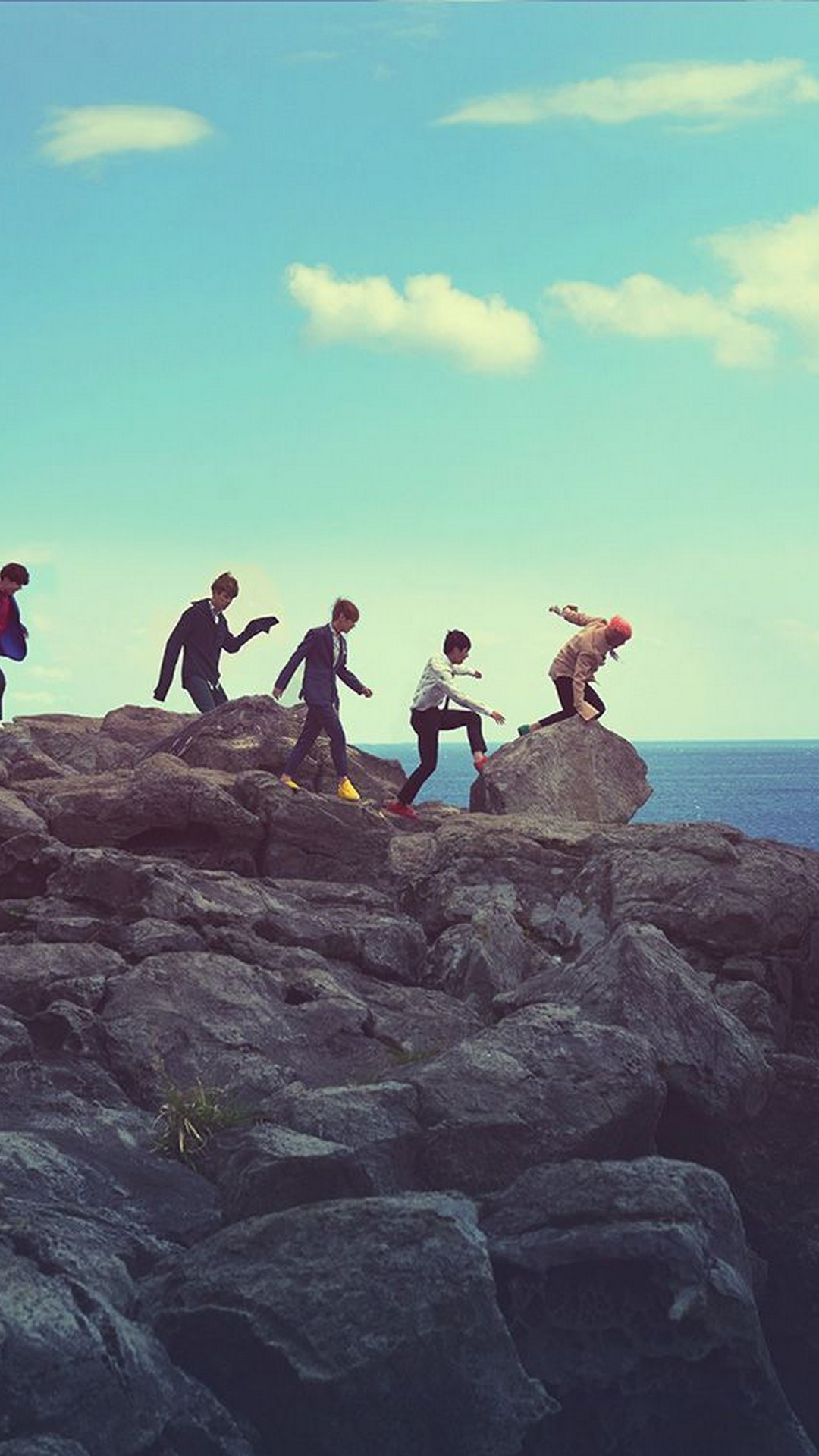 A group of people on top rocks by the ocean - Rocks