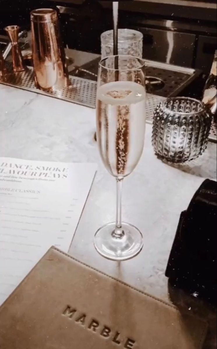 A glass of champagne on a table - Champagne