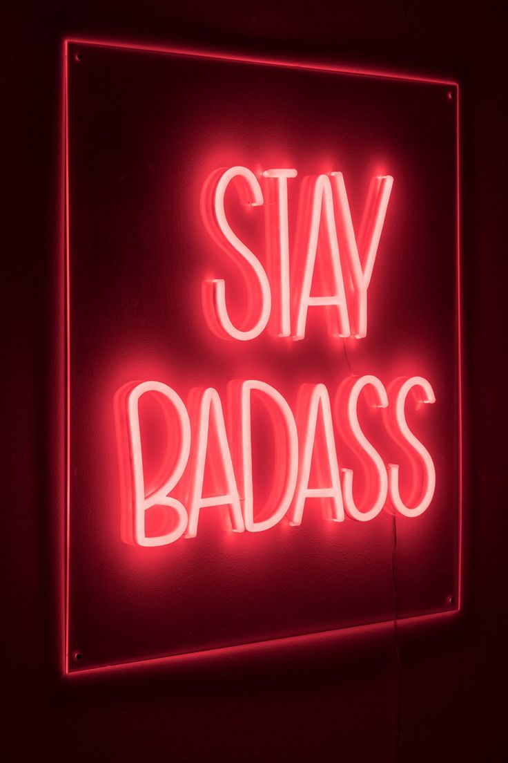 A neon sign that says stay badass - Neon red