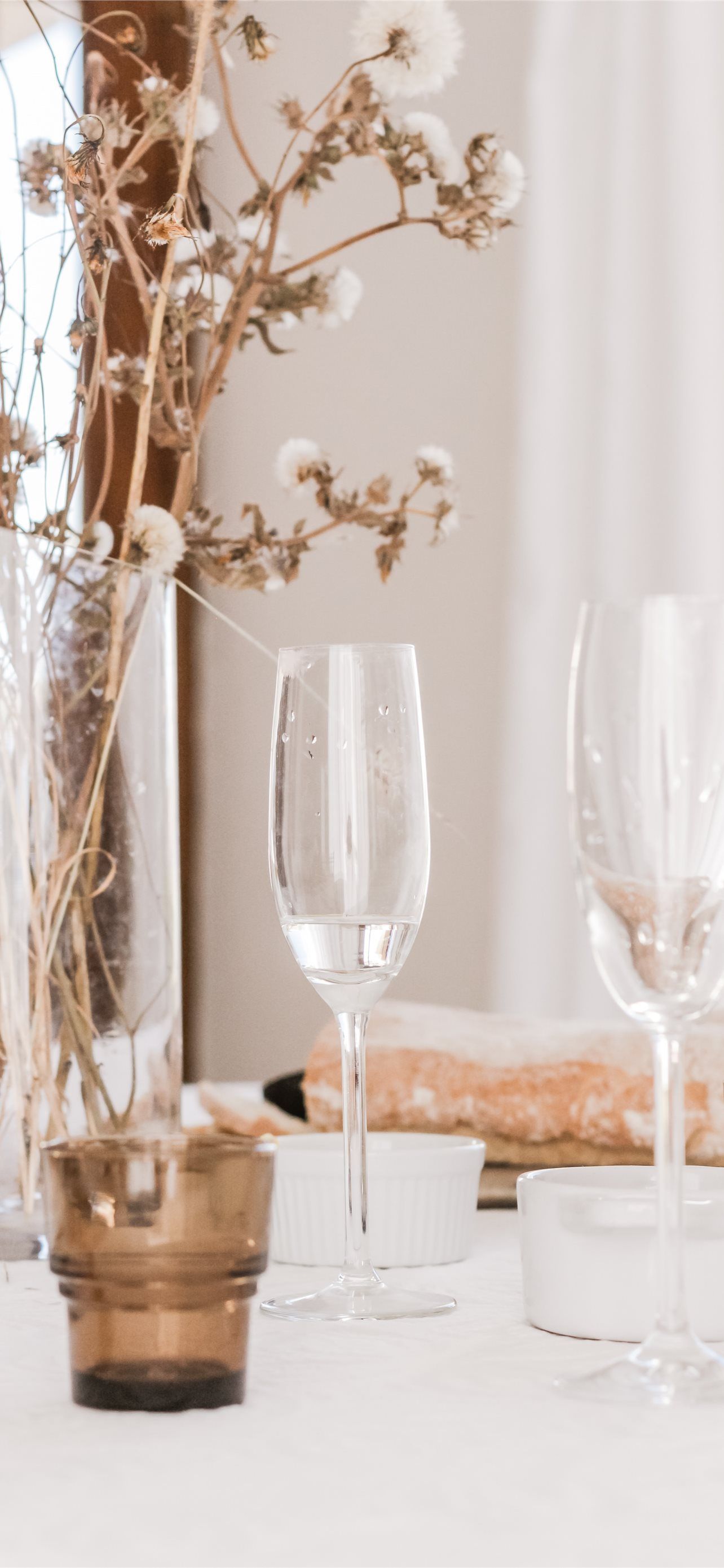 A table with wine glasses and flowers - Champagne