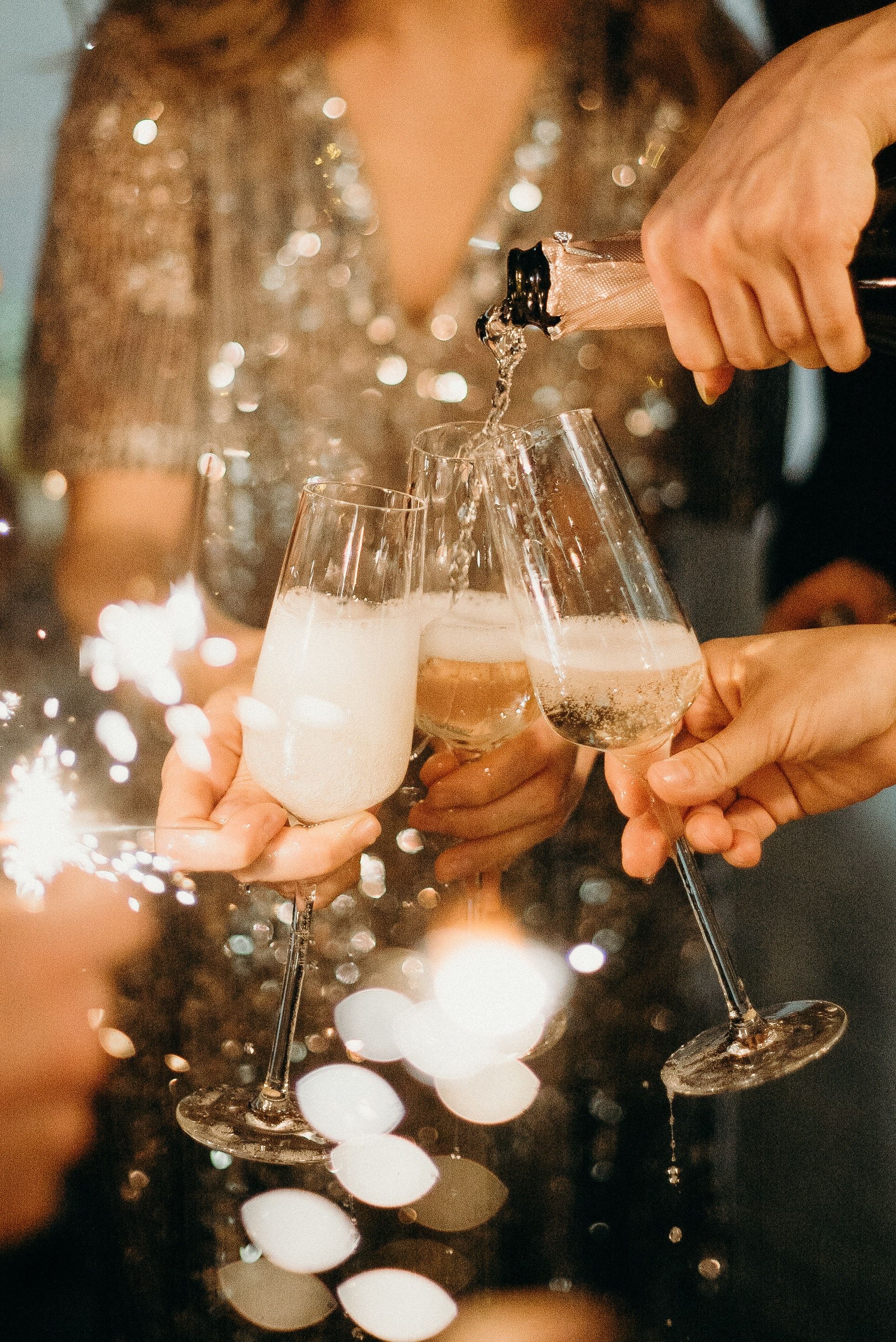 A group of people holding champagne glasses and celebrating - Champagne