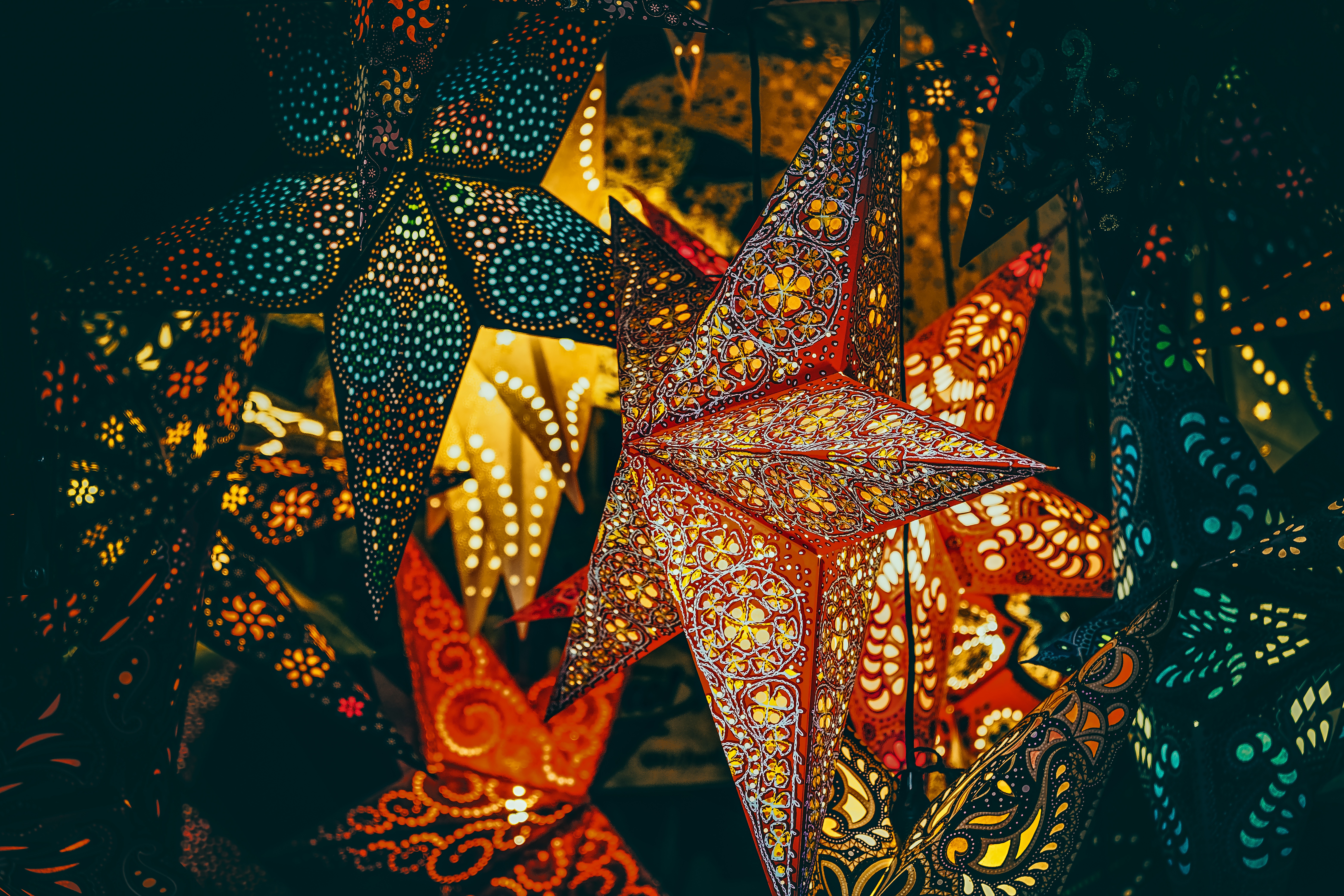 The image shows a collection of colorful, intricately designed paper lanterns. - Christmas lights