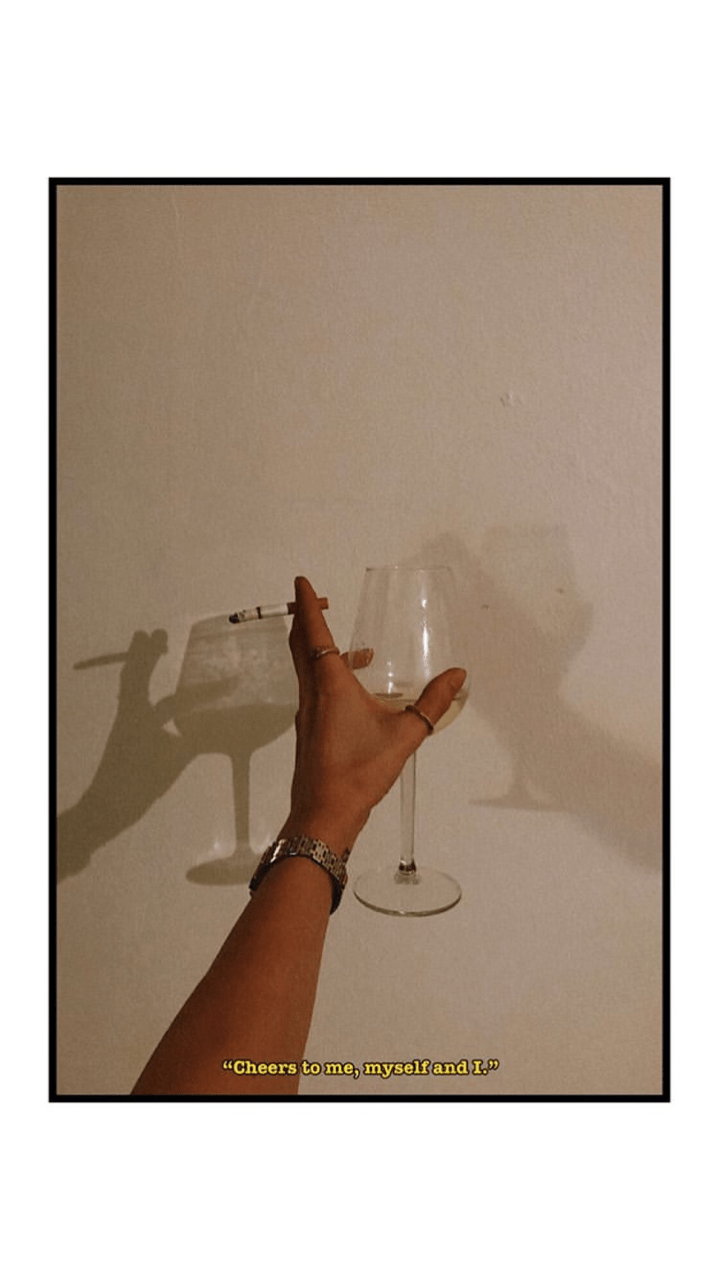 A hand holding up two glasses with shadows - Champagne