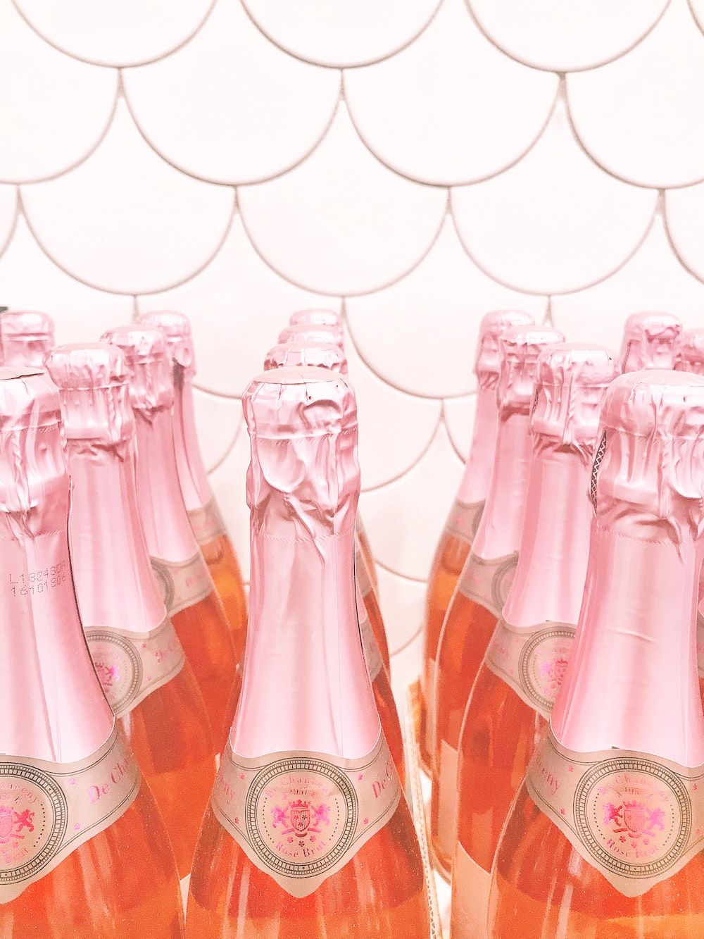 A row of pink bottles sitting on top - Champagne