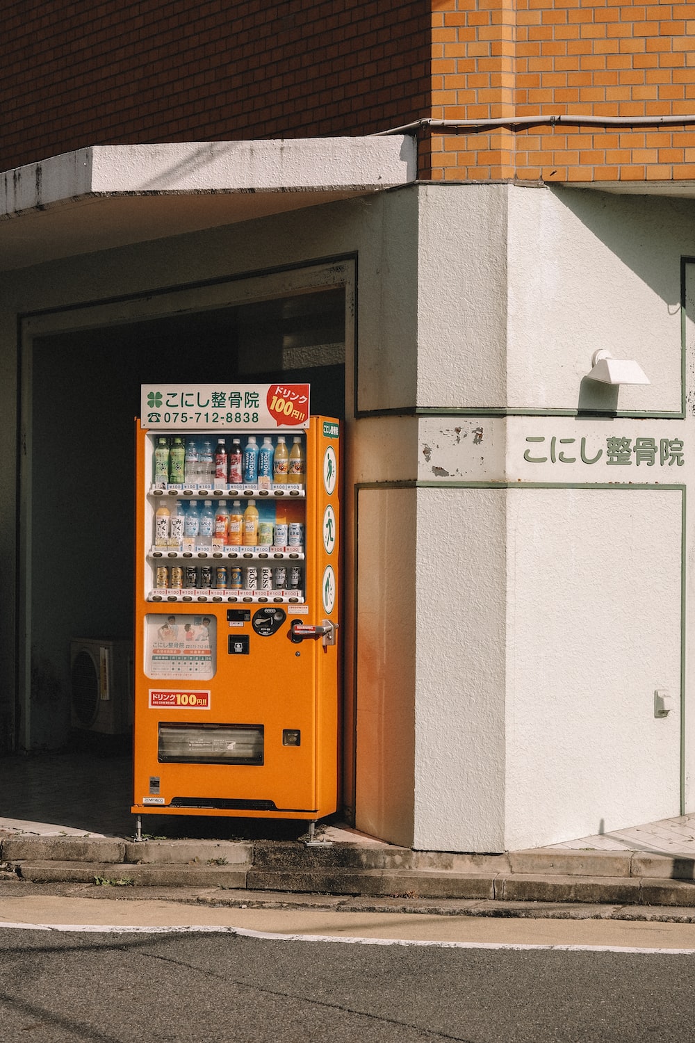 A vending machine is in front of an asian building - Japan