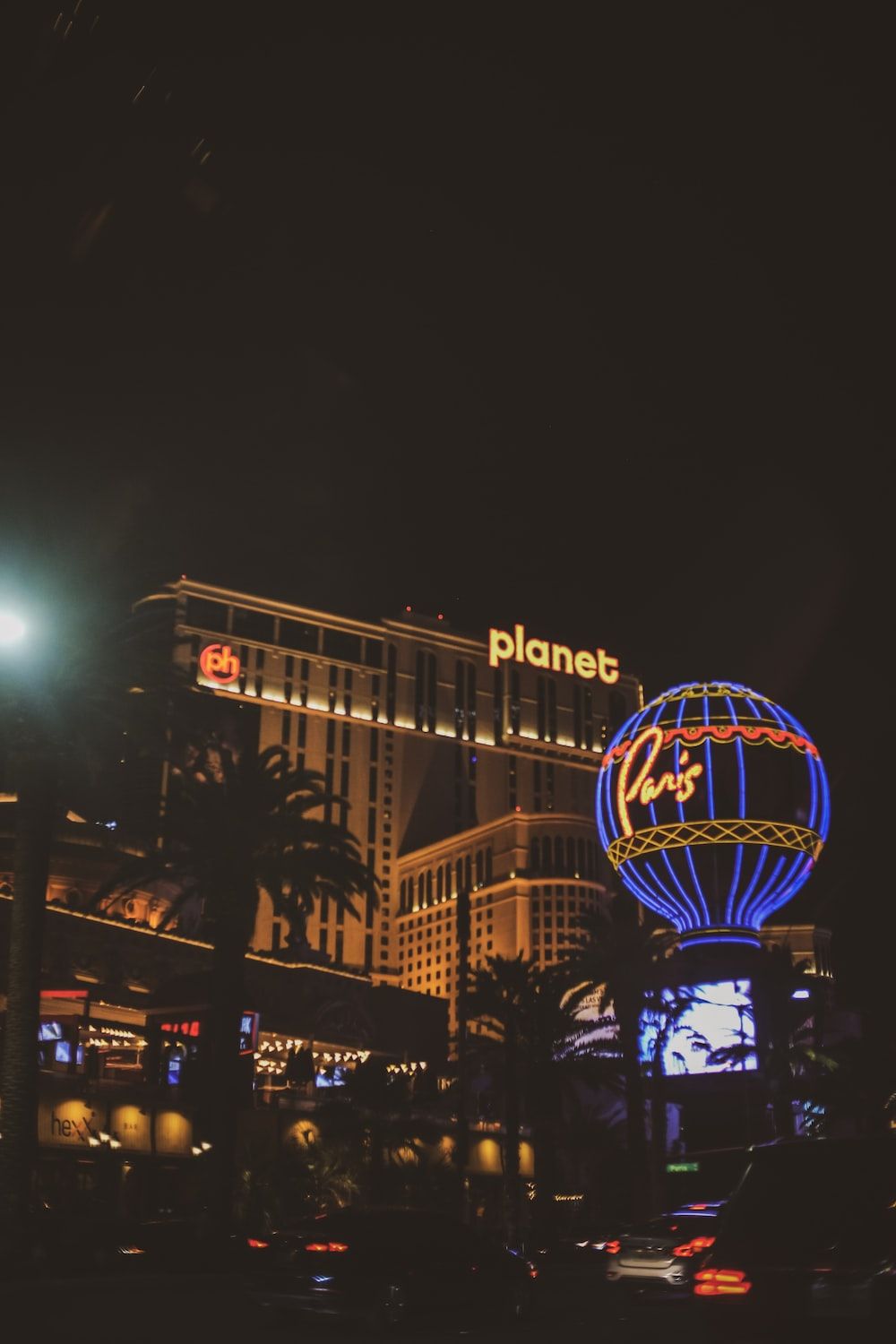 A neon lit sign of Planet Hollywood is seen at night. - Las Vegas