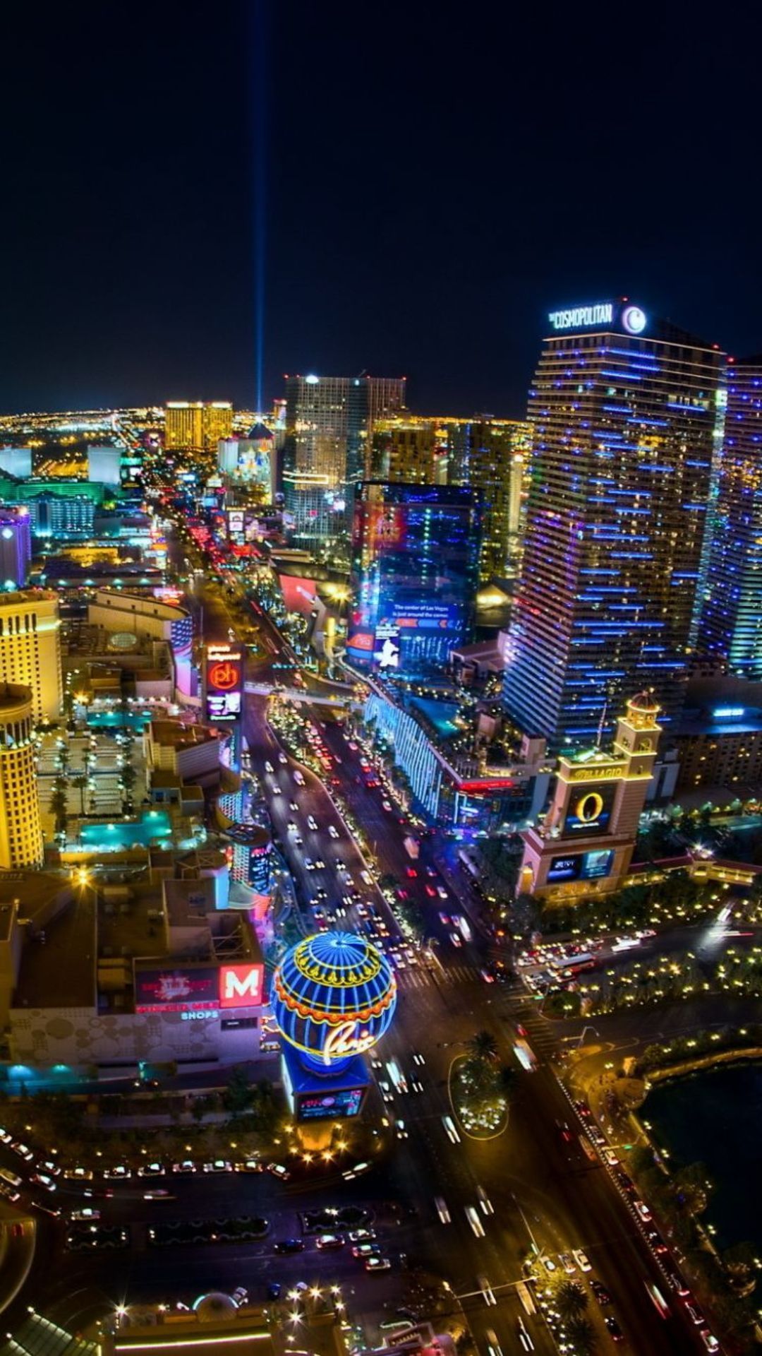 A cityscape at night with bright lights and tall buildings. - Las Vegas