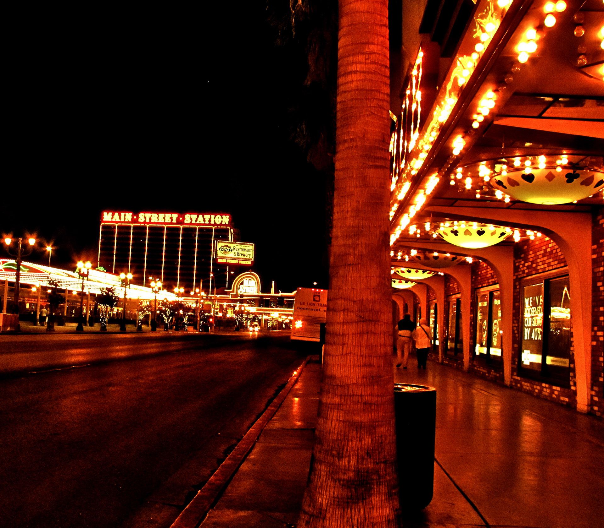 A night time view of Main Street Station with palm trees and street lights. - Las Vegas