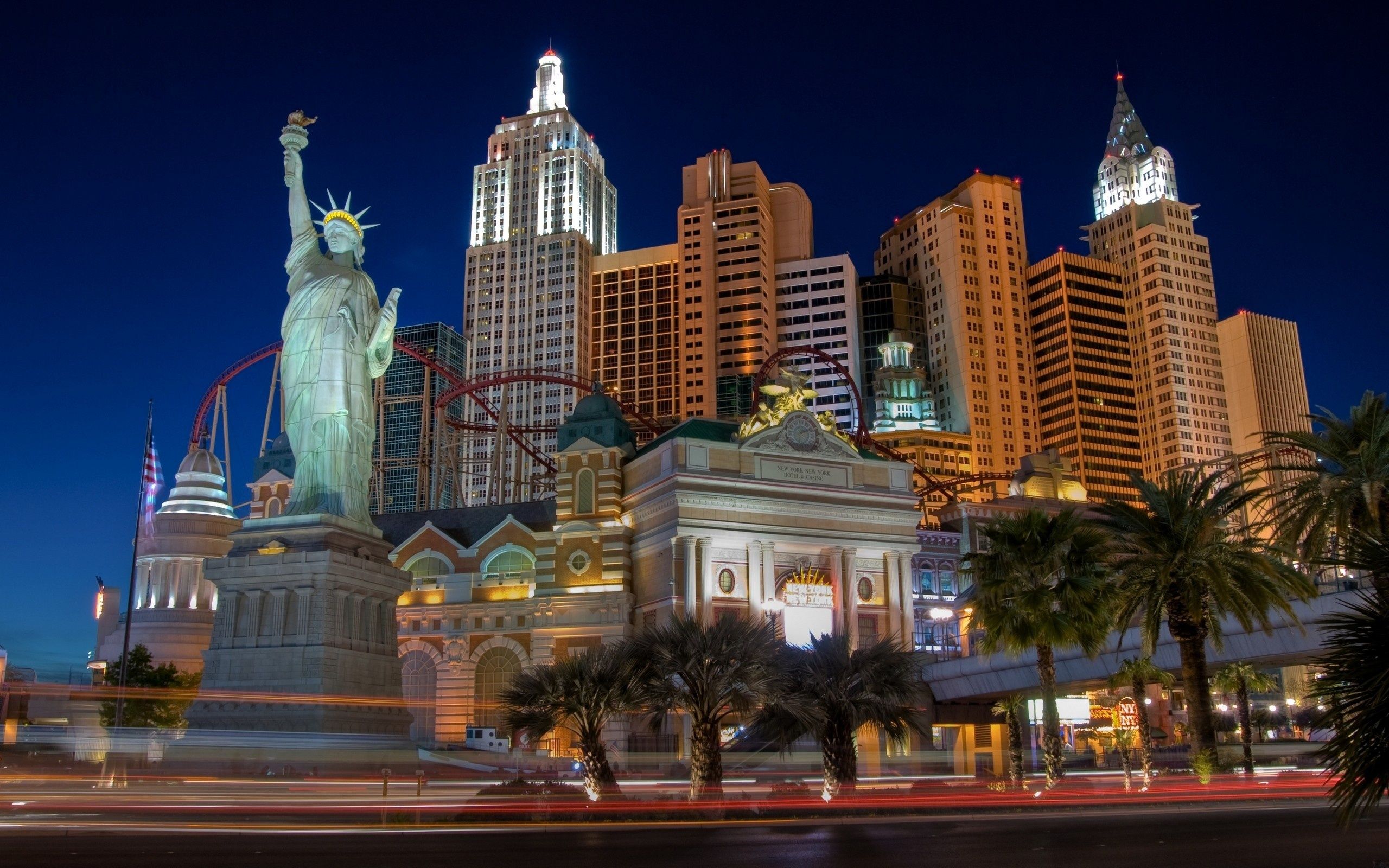 A cityscape with a large building and a replica of the Statue of Liberty. - Las Vegas