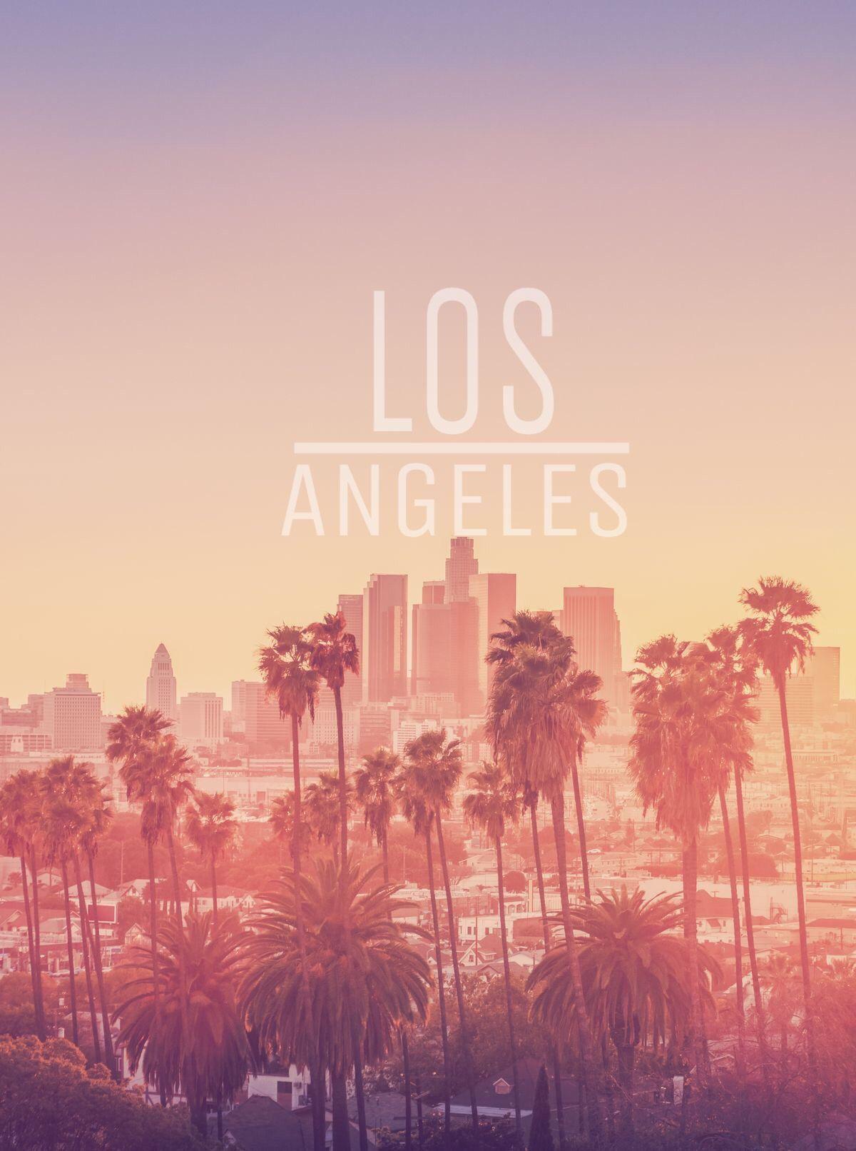 A city skyline with palm trees in the foreground and the word Los Angeles written in white - Los Angeles, California