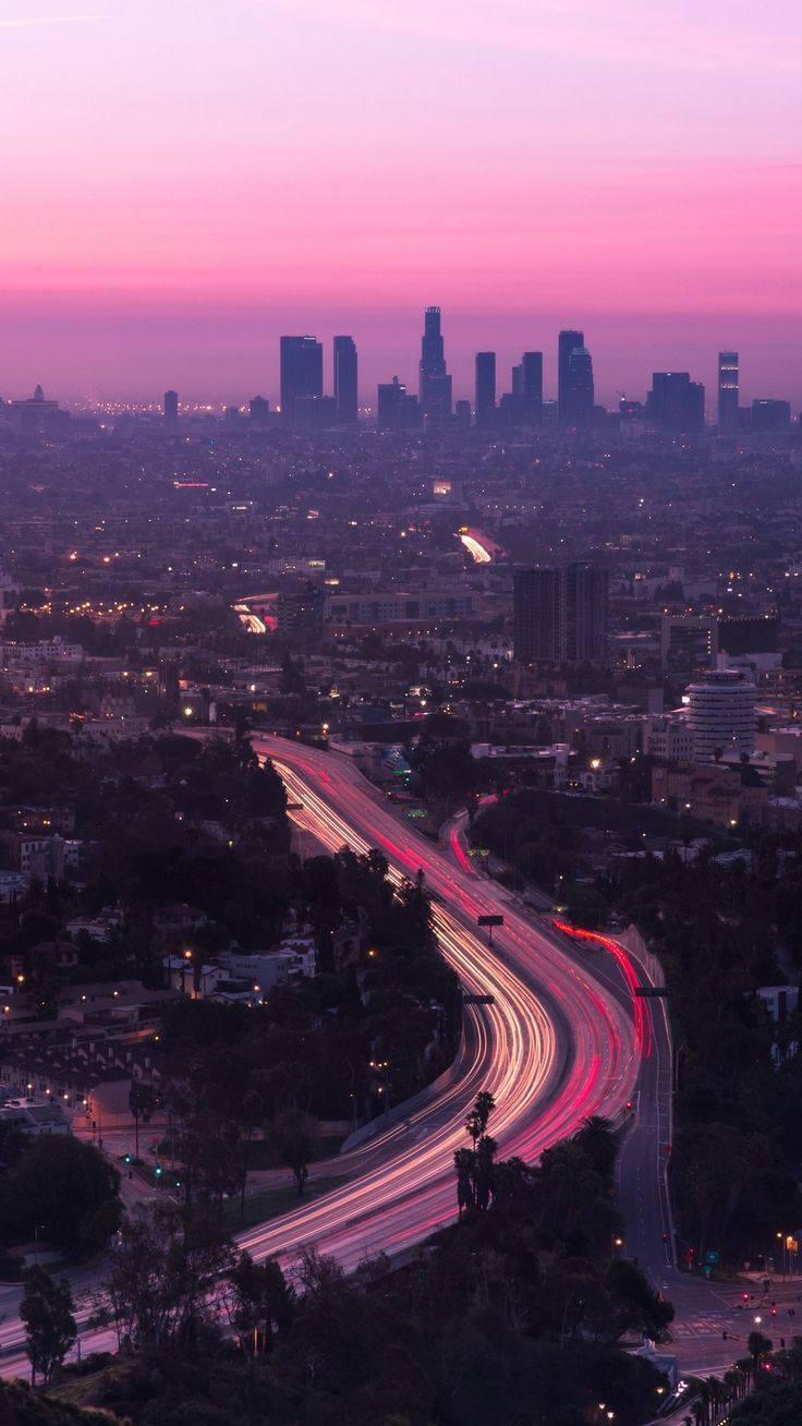 A city skyline at dusk with cars on the highway - Los Angeles, California