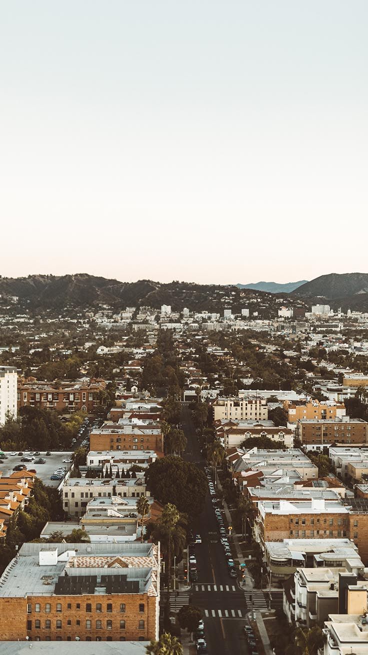 Aerial view of buildings in a city with mountains in the background - Los Angeles
