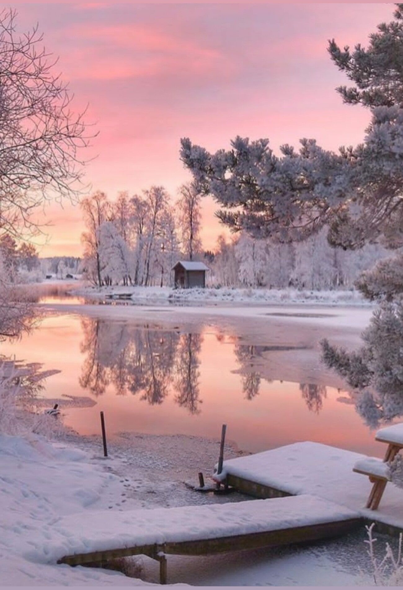 A frozen lake under a pink sky with a small house in the background. - Snow, winter