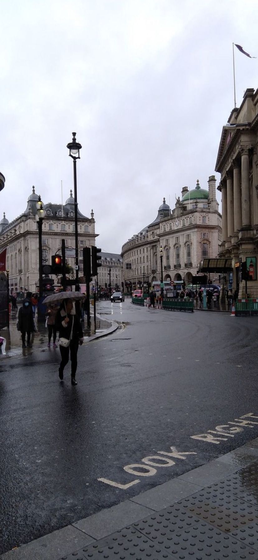 A rainy day in London, England with people walking down the street holding umbrellas. - London