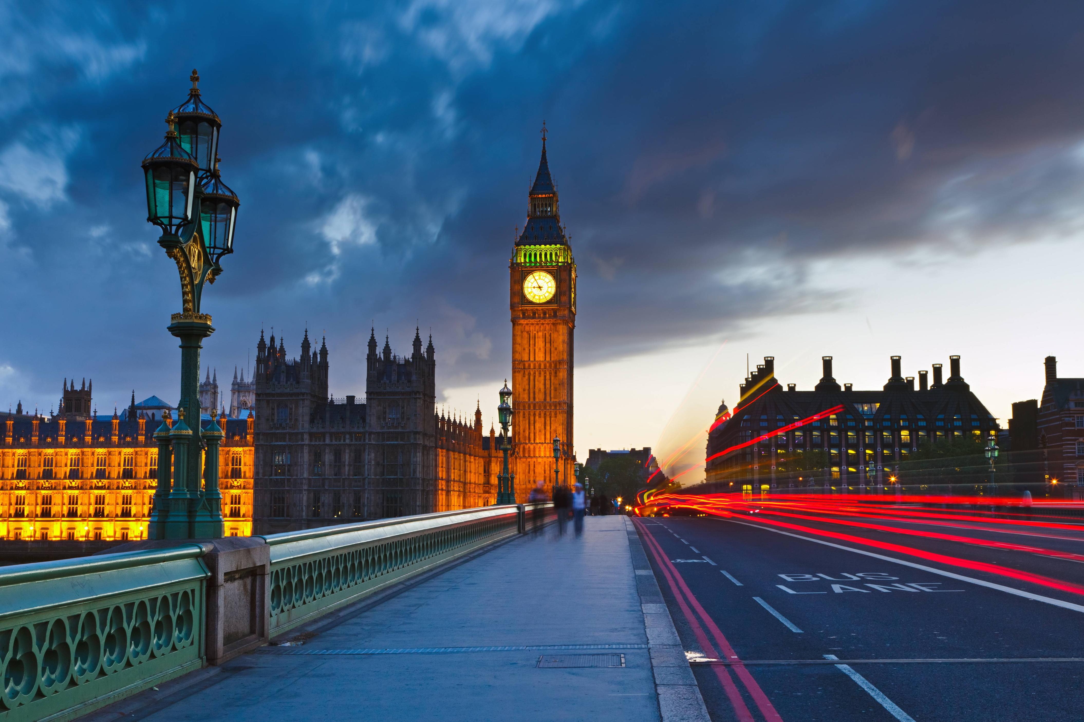 A car drives by the Big Ben clock tower in London. - London