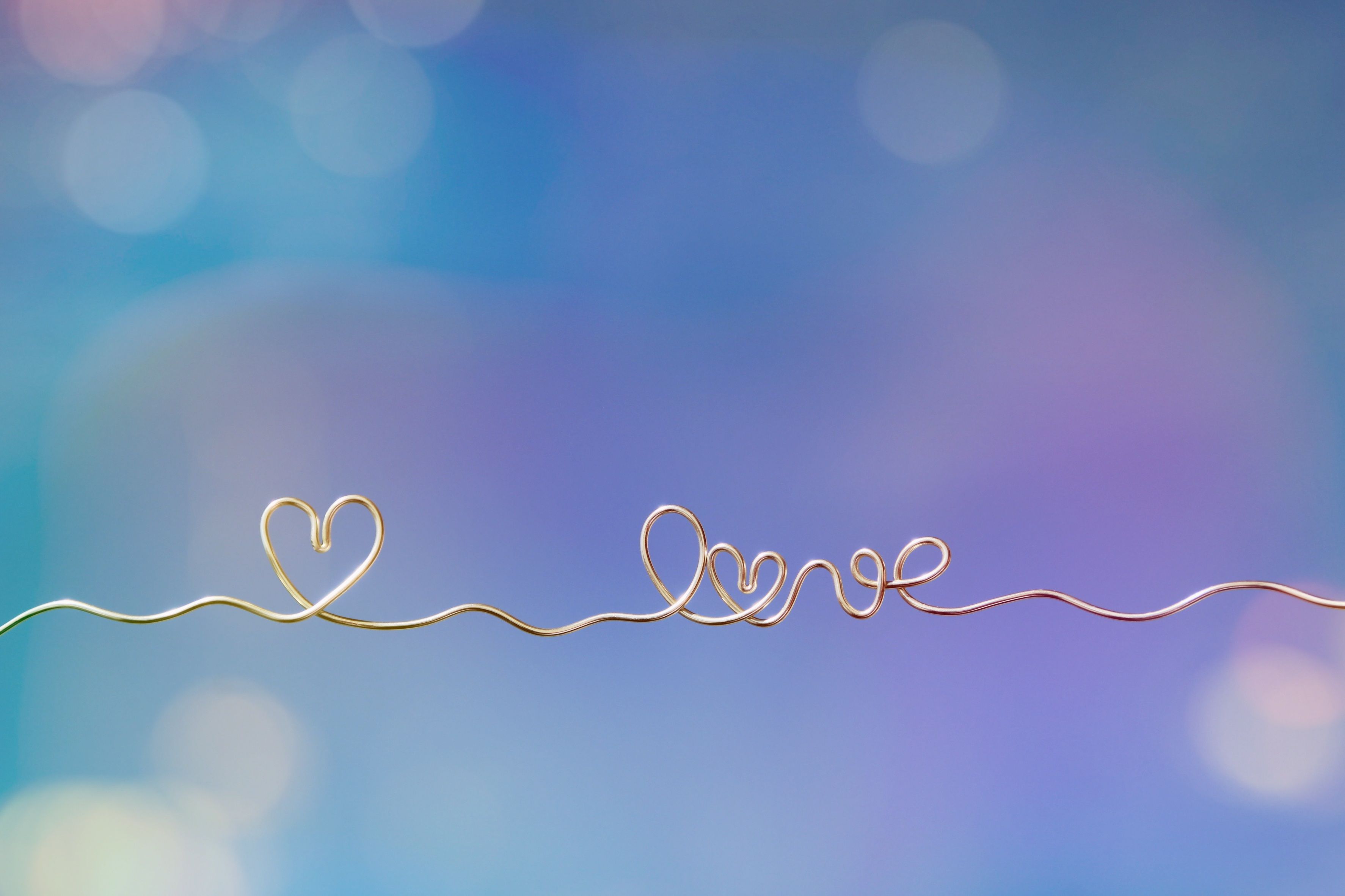 A heart and the word love made out of wire on a bokeh background - Heart, love