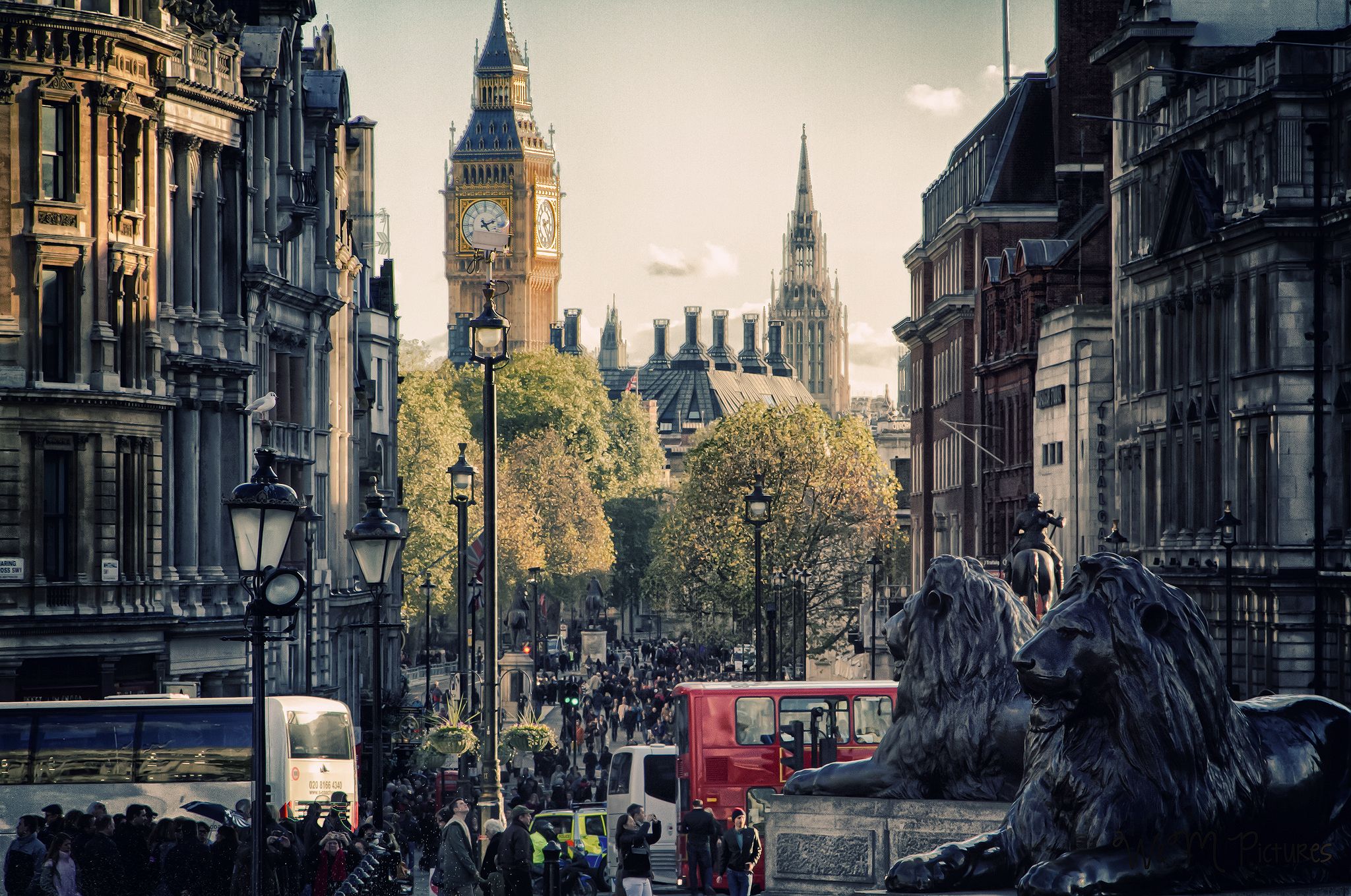 A red bus is driving down the street. - London