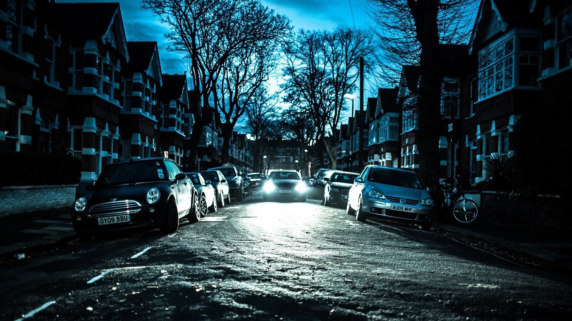 A street with cars parked on it at night - London