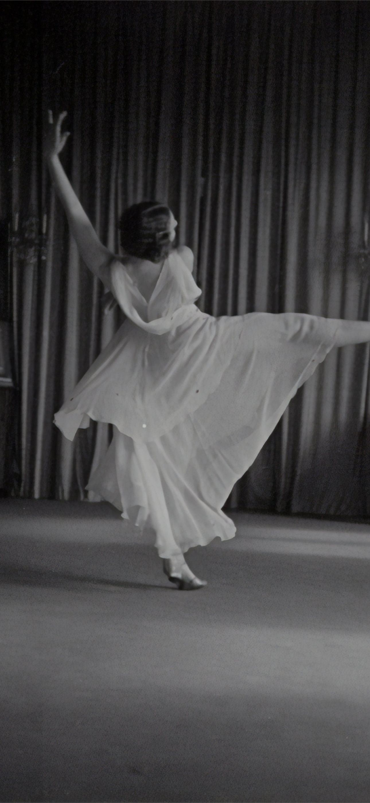 grayscale photo of woman dancing near curtains iPhone Wallpaper Free Download