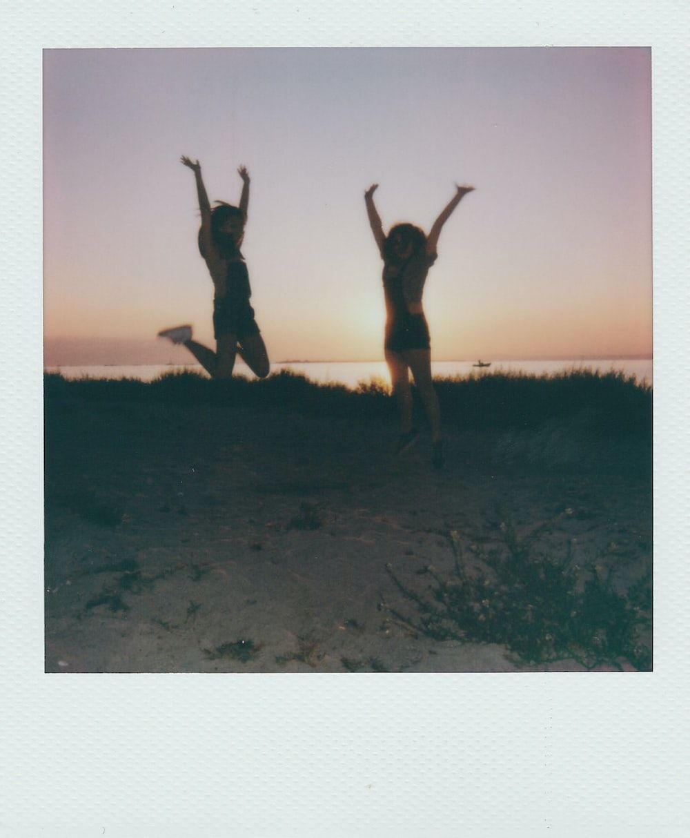 Polaroid of two girls jumping in the air at sunset - Polaroid