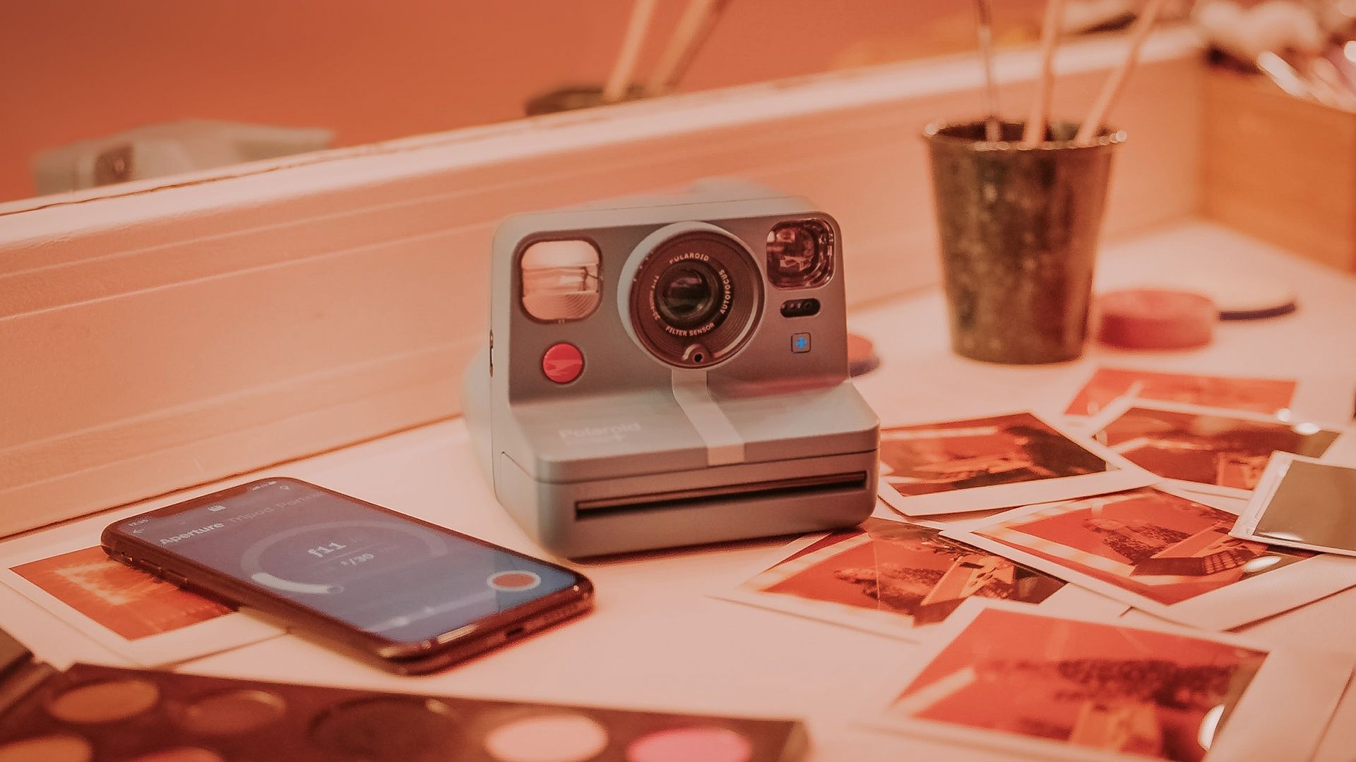 Polaroid camera with instant photos on a table - Polaroid